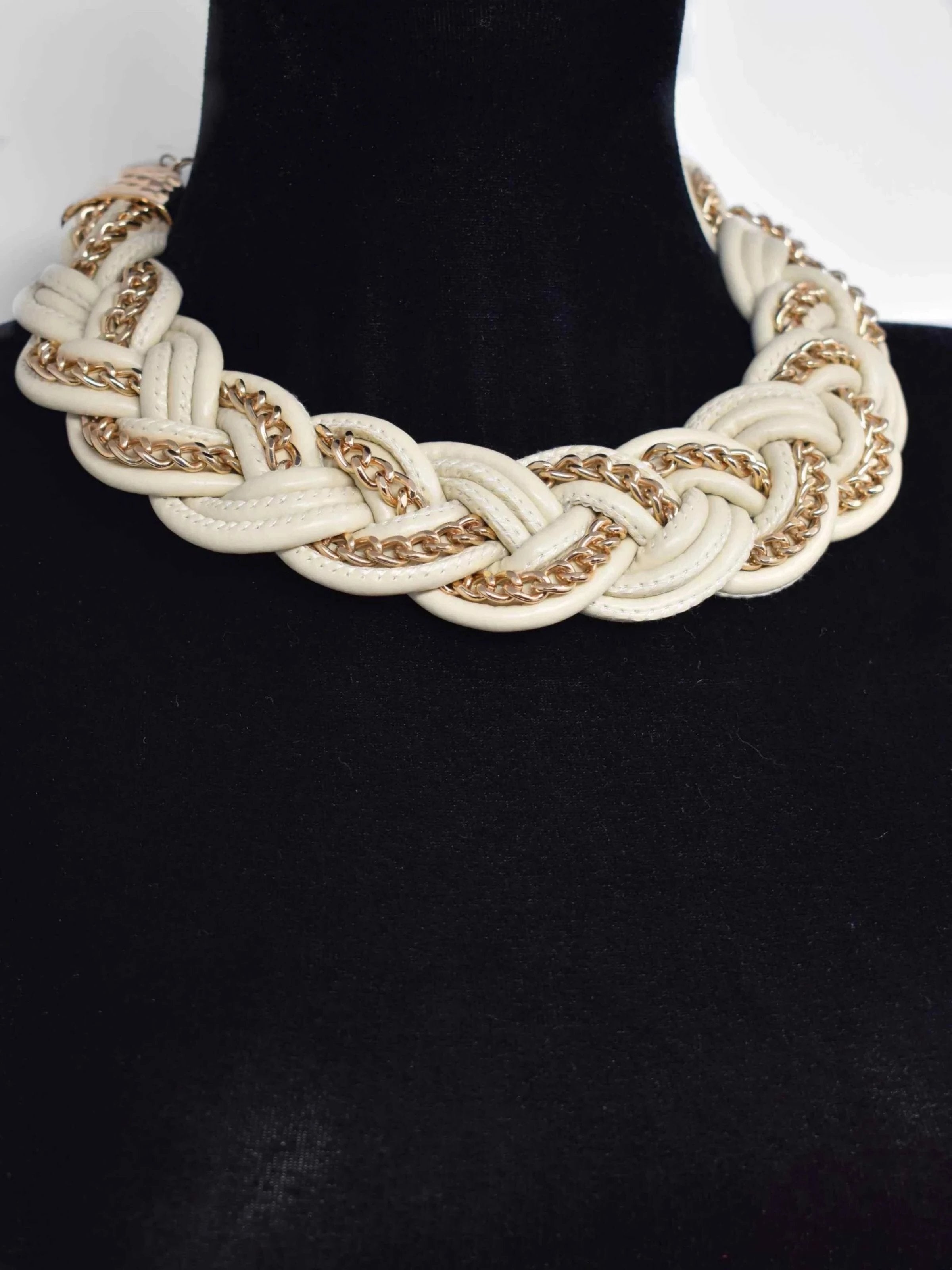 Get all the attention in the Agera statement necklace. This cream braided necklace is accented with gold chain trimming for a unique design. It messures 18" in length and has a lobster clasp.