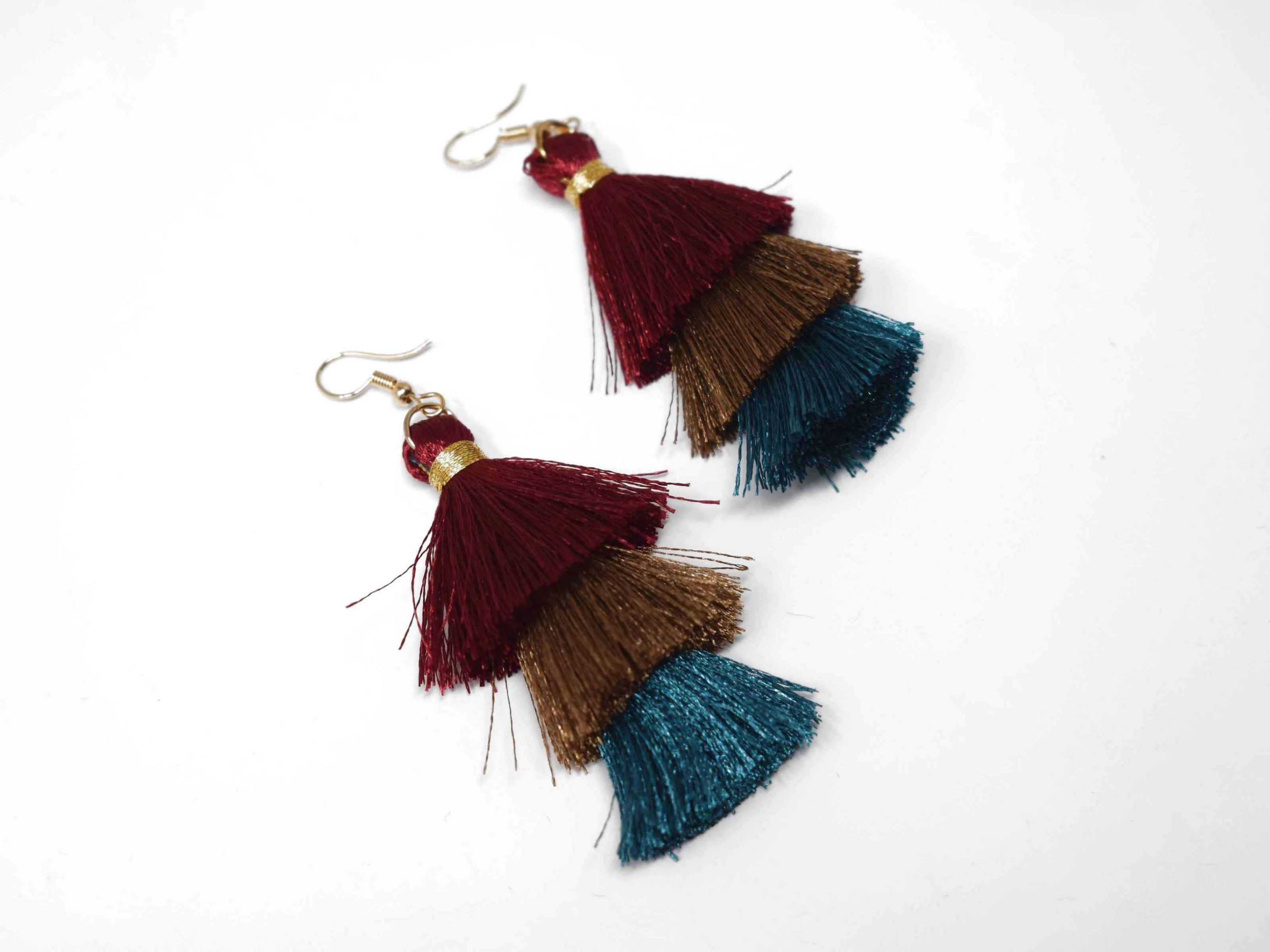 You can count on our Allium earrings to provide you with a little fringe with benefits.  These triple layered burgundy, brown and green fringe earrings are a beautiful addition with there fish hook clasp. They measure 3 1/2" in length.
