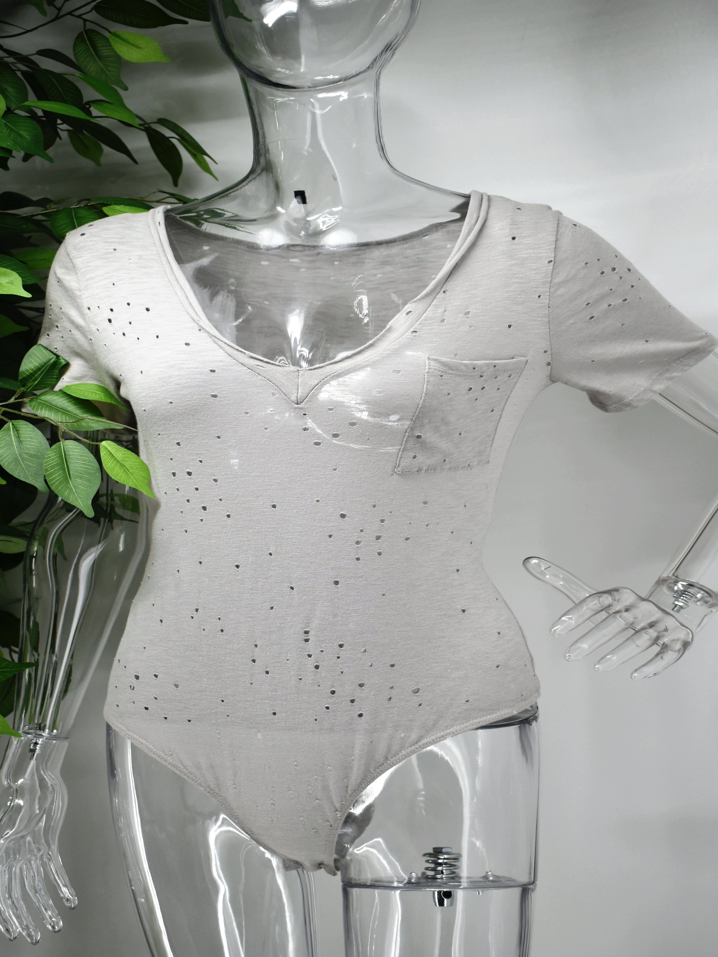 Dressed up or worn casual our Beata cotton body suit is multifaceted. Our Beata is a cotton t-shirt  with a fashionable twist . This V neck shirt has a bodysuit design with edgy punched holes through out the bodysuit.