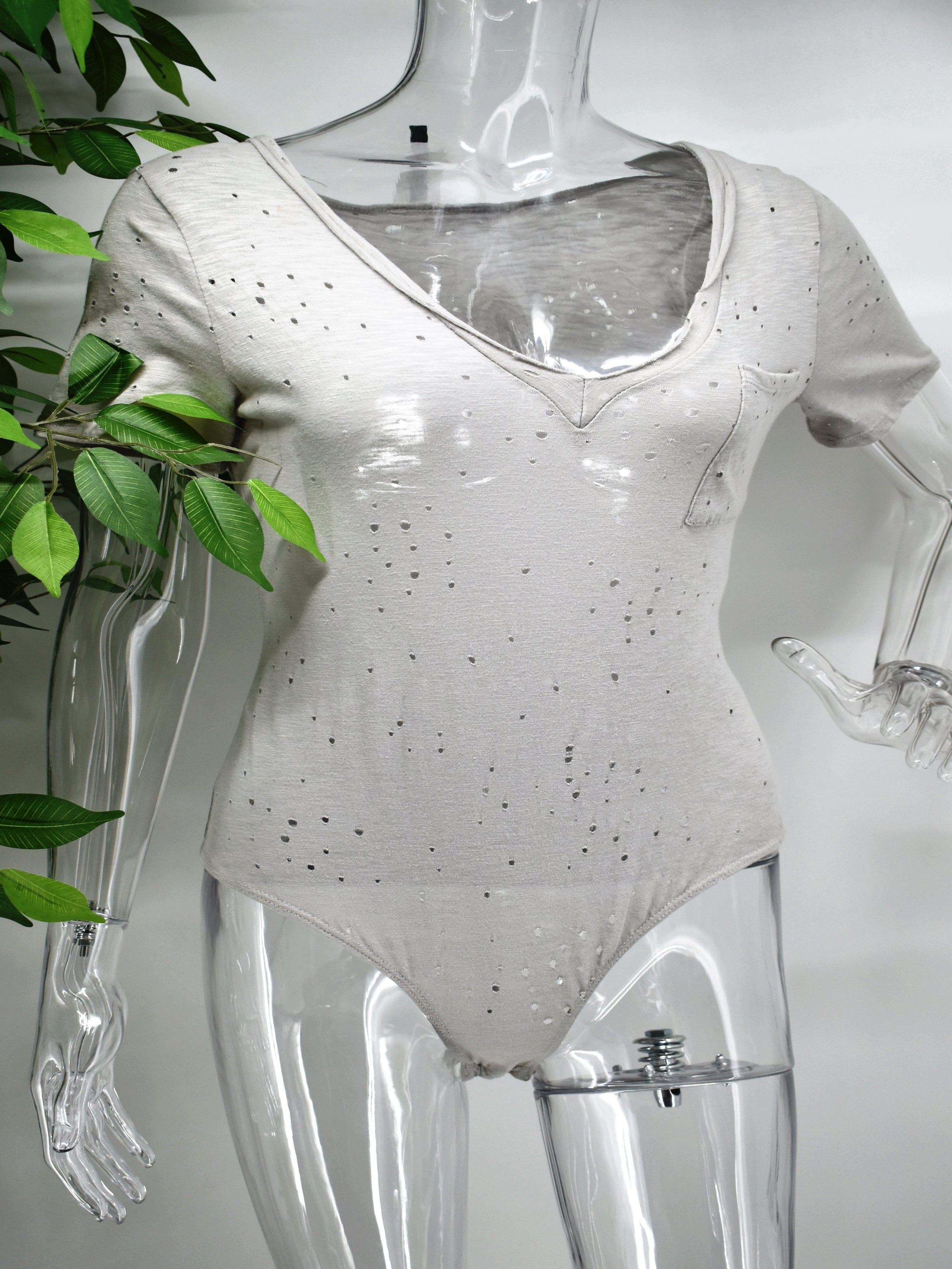 Dressed up or worn casual our Beata cotton body suit is multifaceted. Our Beata is a cotton t-shirt  with a fashionable twist . This V neck shirt has a bodysuit design with edgy punched holes through out the bodysuit.