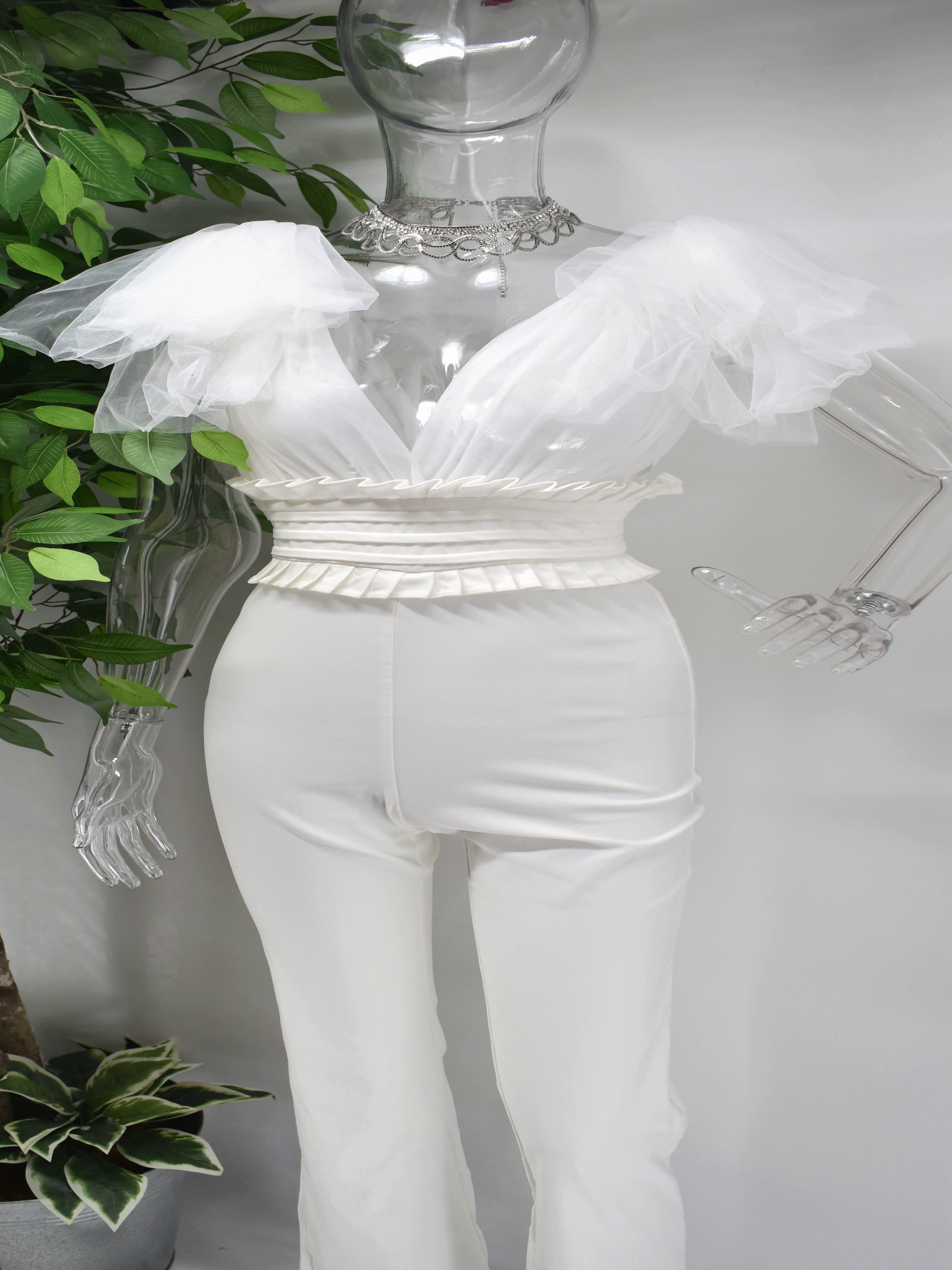 Turn heads and star the show in our Bentleigh White Jumpsuit. Bentleigh is a white pants jumpsuit with a sheer v-neckline top and a ruffled cinched waist. Its frill sheer sleeve adds just the right amount of drama without going over board.