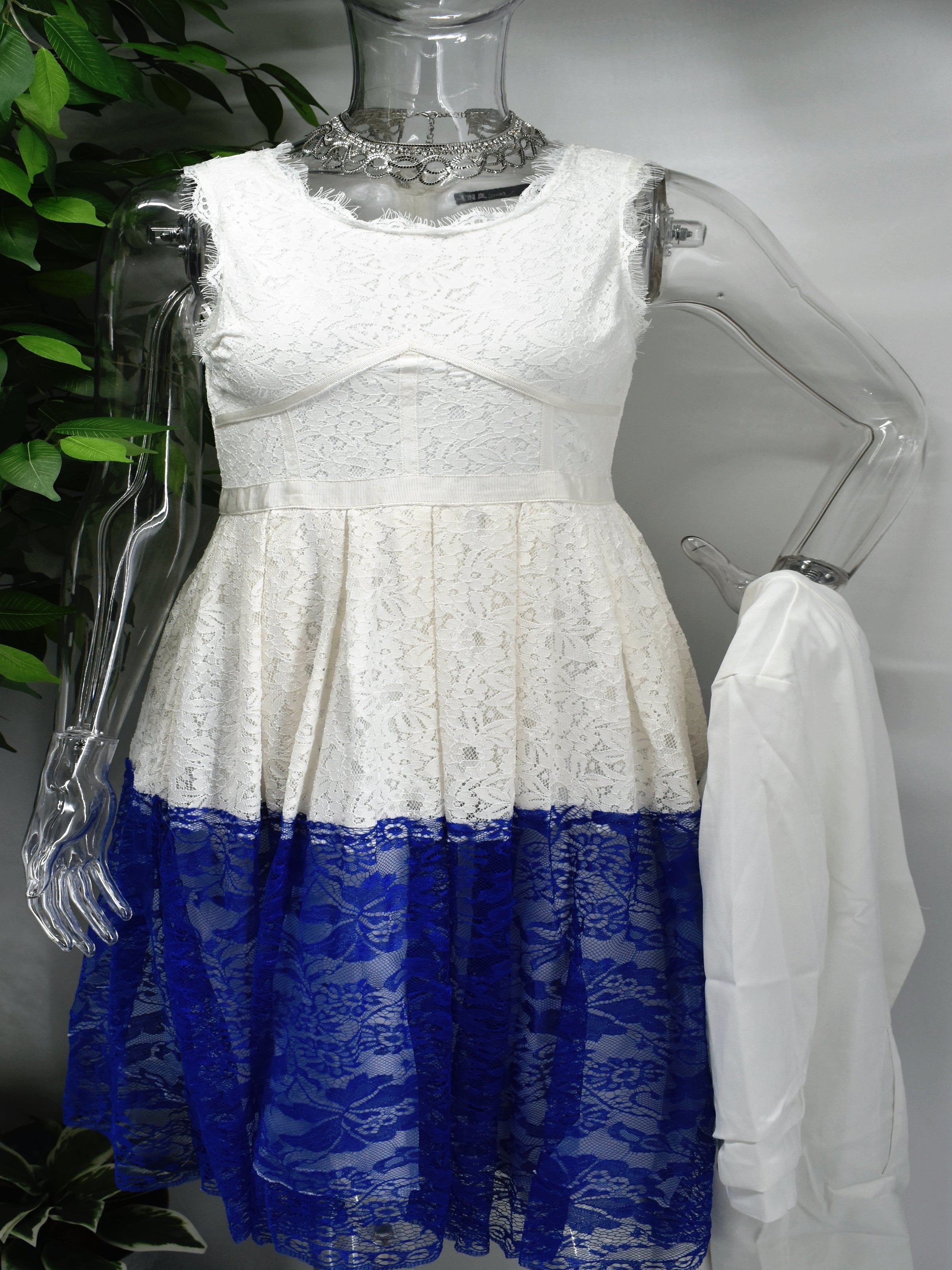 Enjoy how easy it is to wear our Bethea dress from sunrise to sunset. Bethea is a midi length white and blue lace dress. It is sleeveless with a scoop neckline, fitted bodice and a flared skirt. 