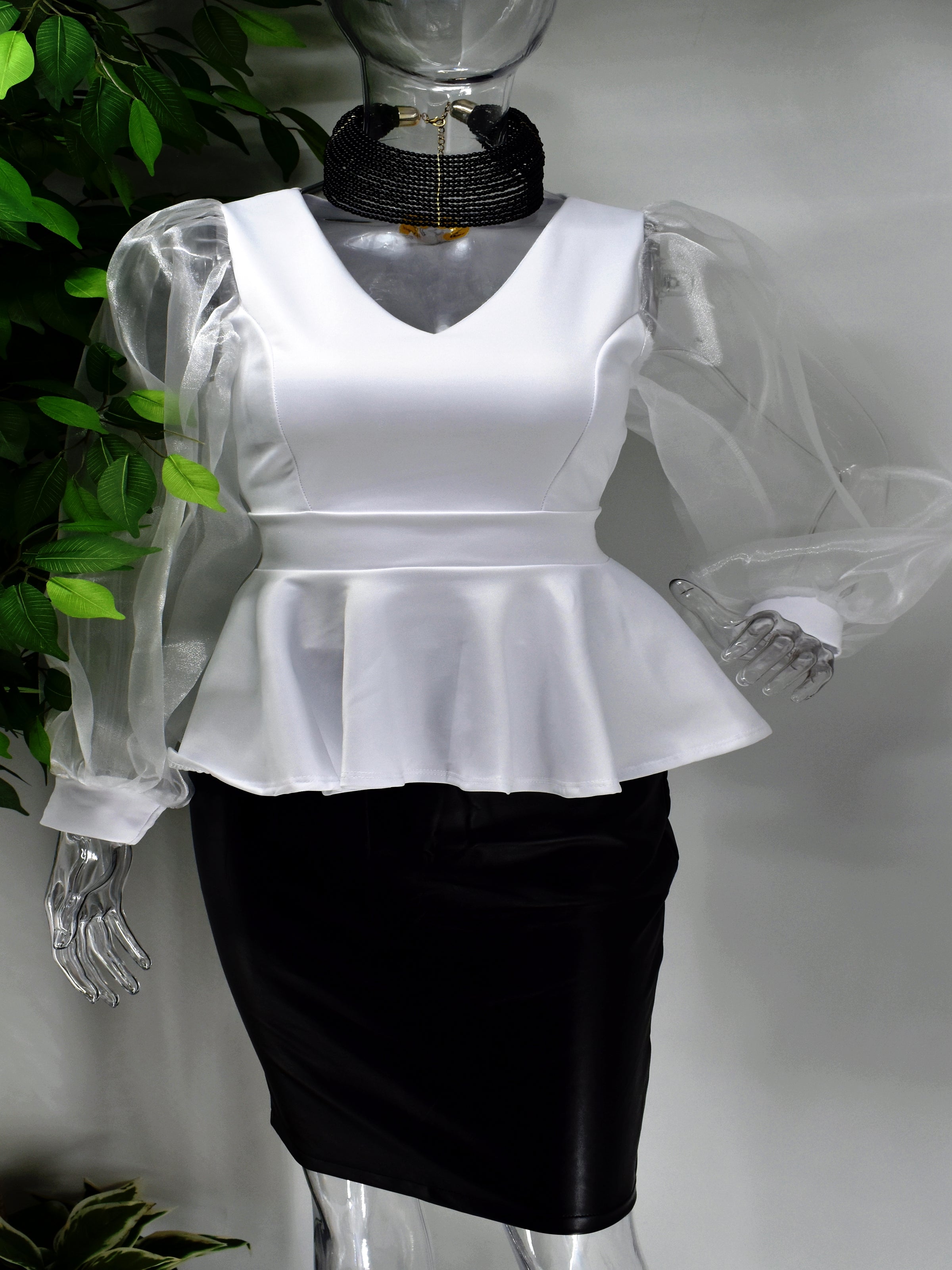 All eyes will be on you in our Bettine white peplum top. Our Bettine has a v- neckline with a beautiful peplum design. Classic and chic it is complimented by a sheer balloon sleeve design. 