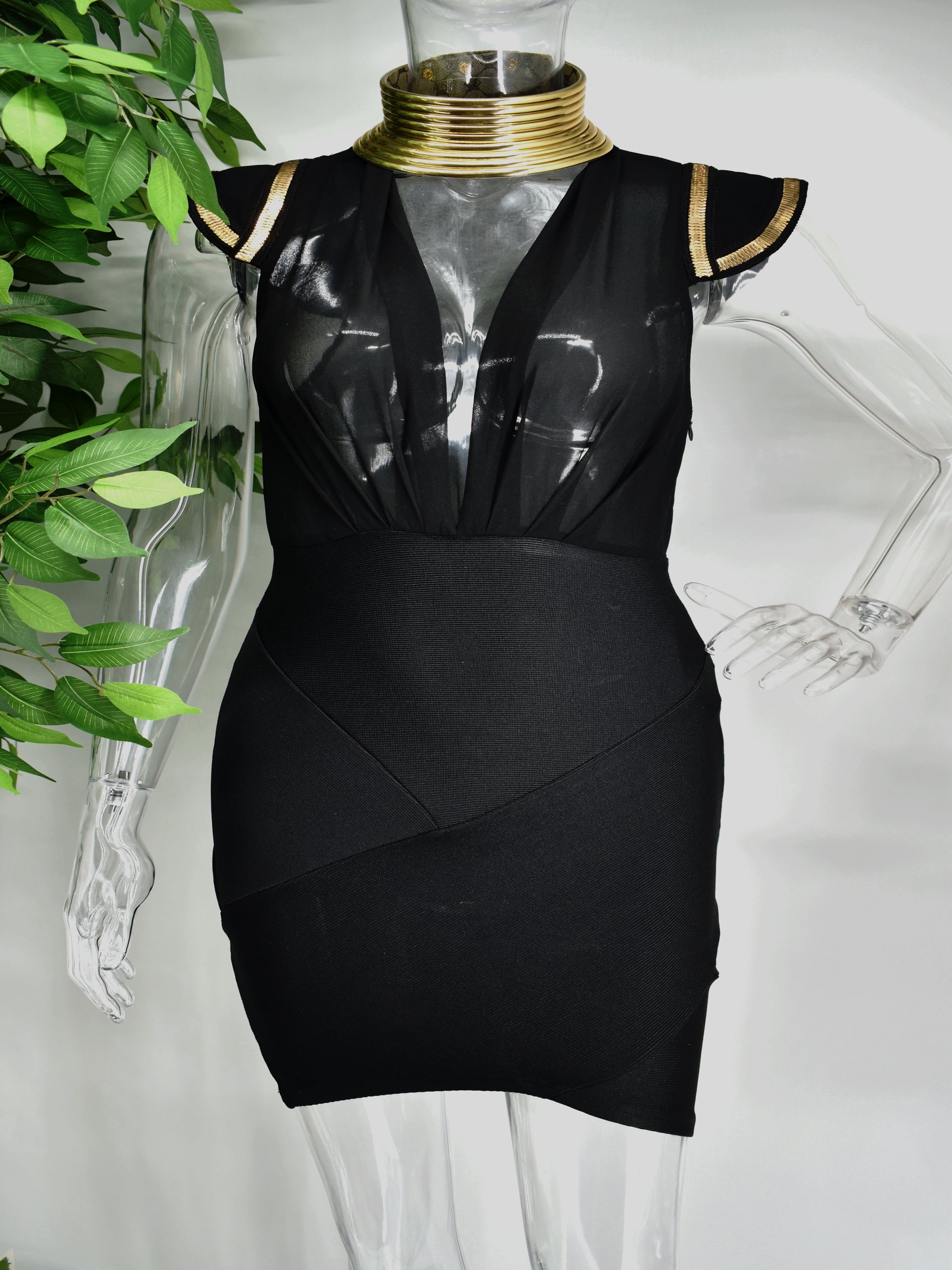 Our Bianca is a black Bandage dress with a sheer bodice and fitted bandage skirt. The capped sleeves are adorned with gold accents to compliment the open v neckline.