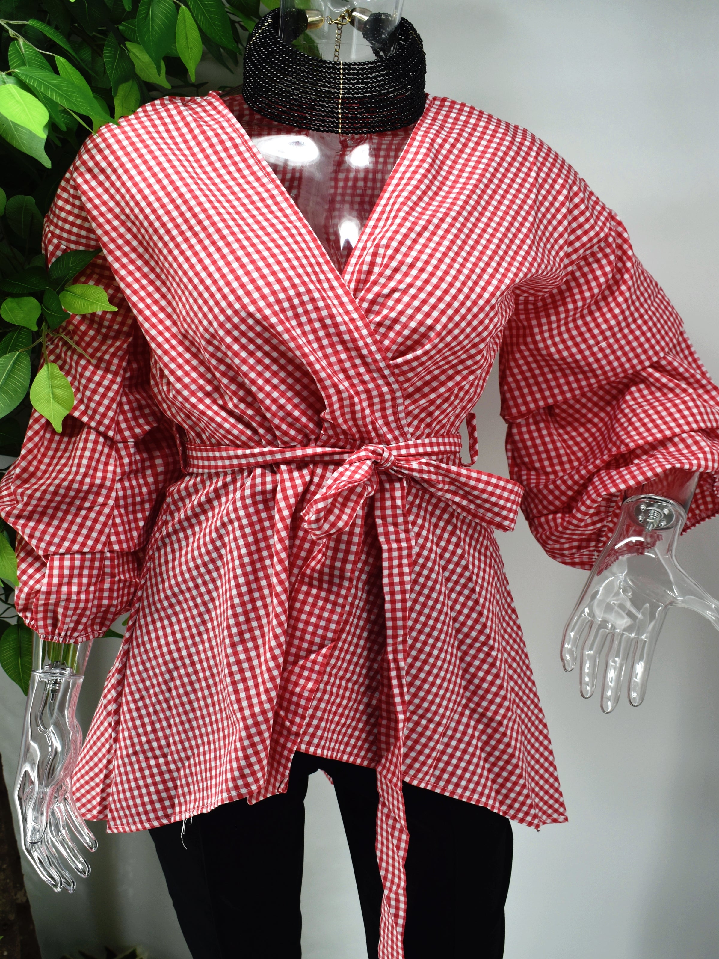 A classic print meets a modern design with our Birdina red and white gingham print top. Our Birdina is full of style and pizzaz. It has a v-neckline, ruffled puffed sleeve and an uneven hem. The design is completed with a tied cinched waist.