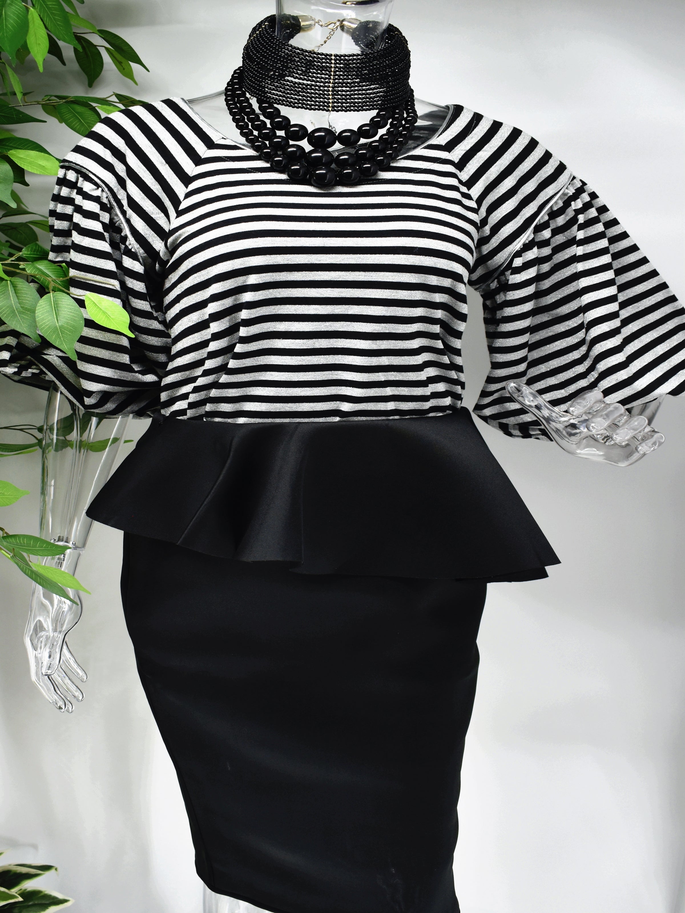 Bring a modern design to a classic staple when you step out in our Bobette stripe top. Bobette has a black and gray striped design with a bateau neckline that is beautifully paired with our high fashion puffed bell sleeve.