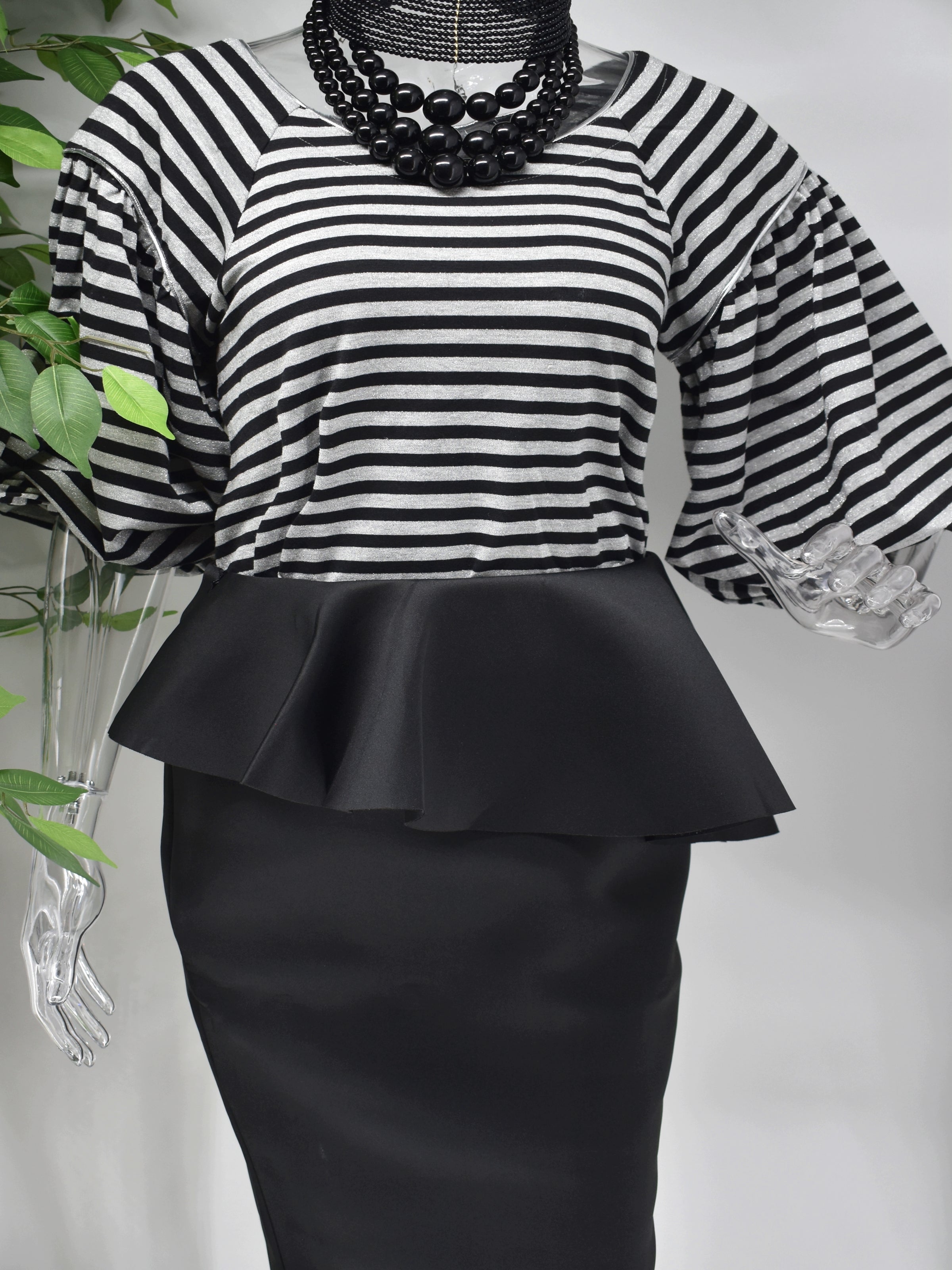 Bring a modern design to a classic staple when you step out in our Bobette stripe top. Bobette has a black and gray striped design with a bateau neckline that is beautifully paired with our high fashion puffed bell sleeve.