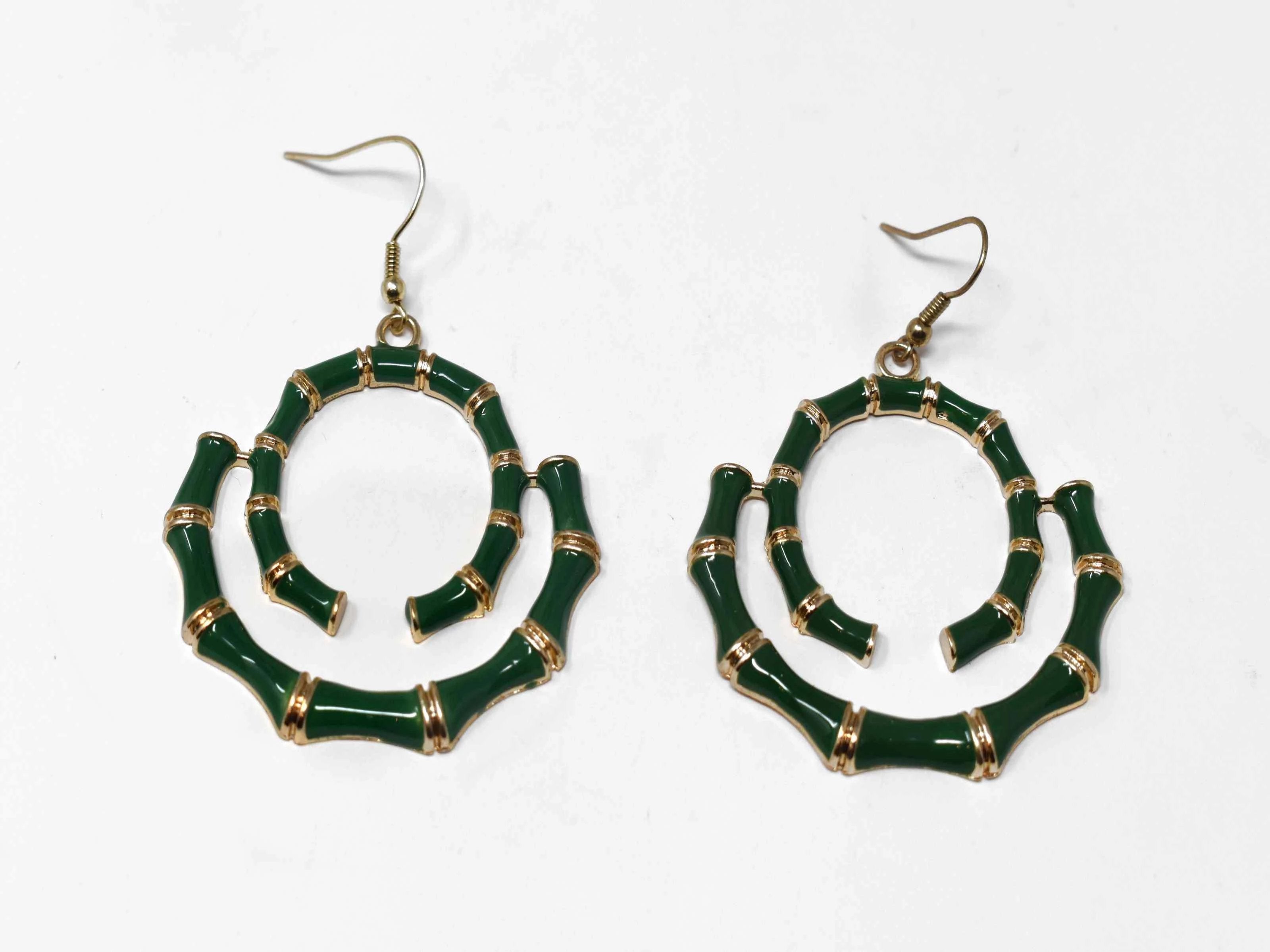 Our Bombays carved bamboo style earrings with a fish hook clasp is gold in tone and green in color. It has a swirled bamboo design measuring 2 1/2" inches in length. 