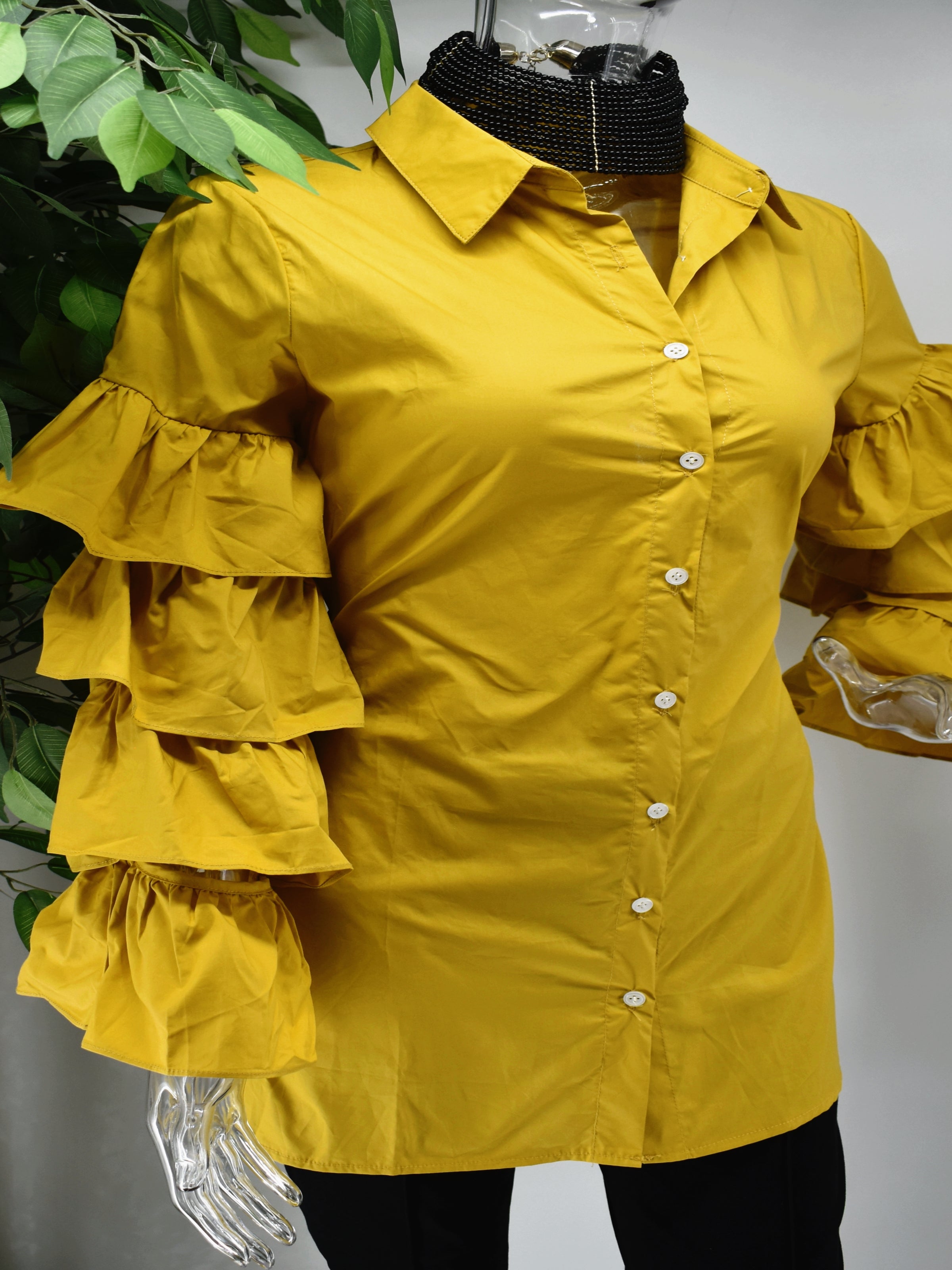 Turn heads and represent how fashionably fierce you are in our Brandis Mustard ruffle sleeve shirt top.  Our Brandis is a long button front shirt top with a traditional collar and a romantic bold four tiered ruffle sleeve.