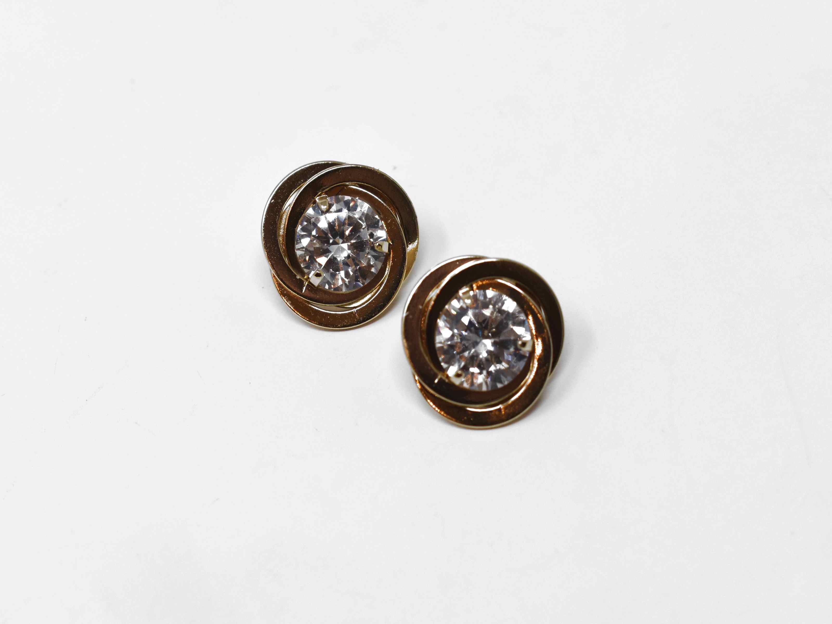 Our Buttercup gold earrings makes a cute statement for every occasions. They have three rings linked together centered by a clear stone. It has a push back clasp and a 1/2 inch in length.