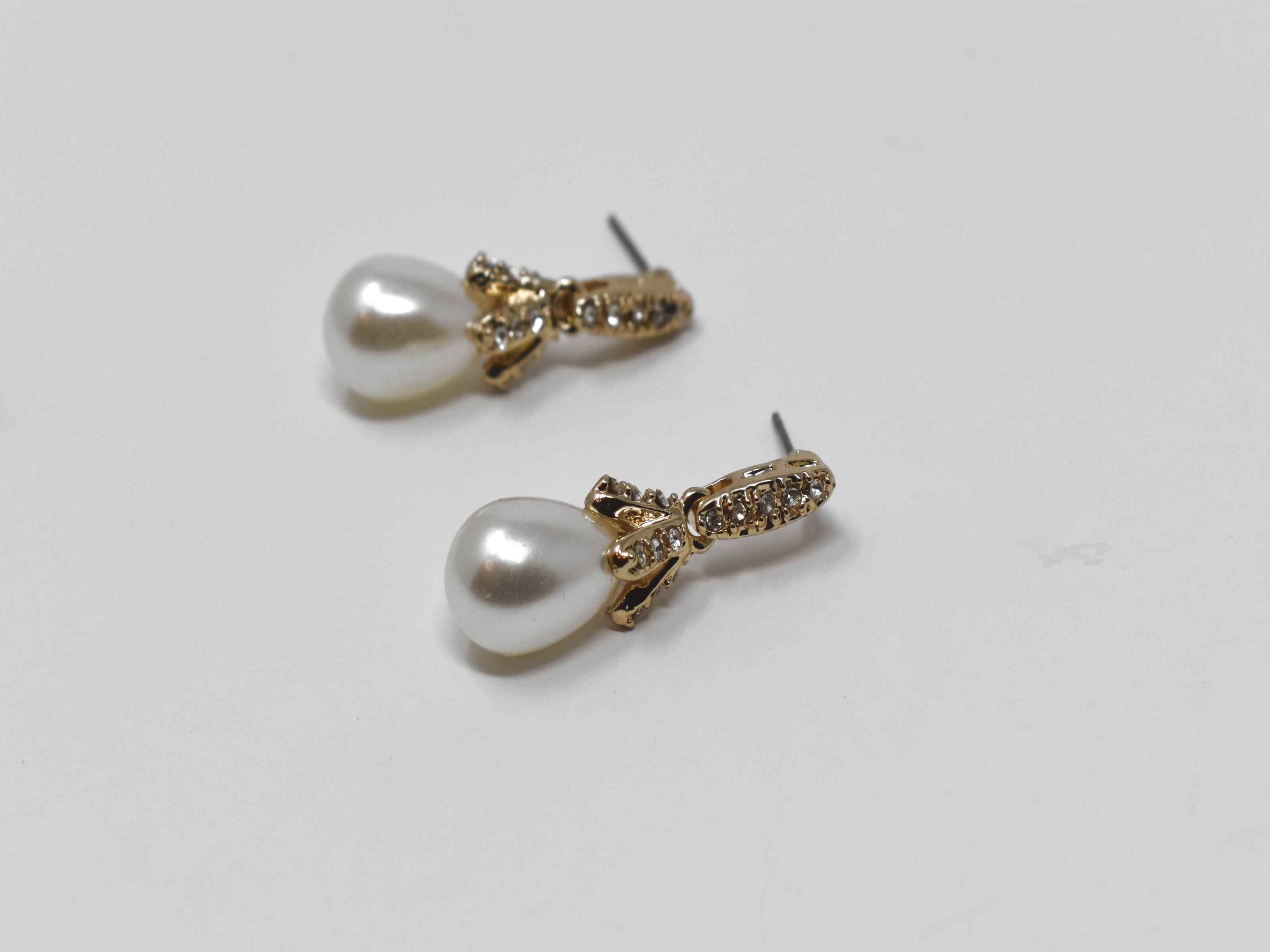 Our Daffodil earrings are a modern take on a classic staple. These gold dangle knob earrings has a pearl core with an accent of stones. It is  1 1/4 inches in length with a push back clasp.