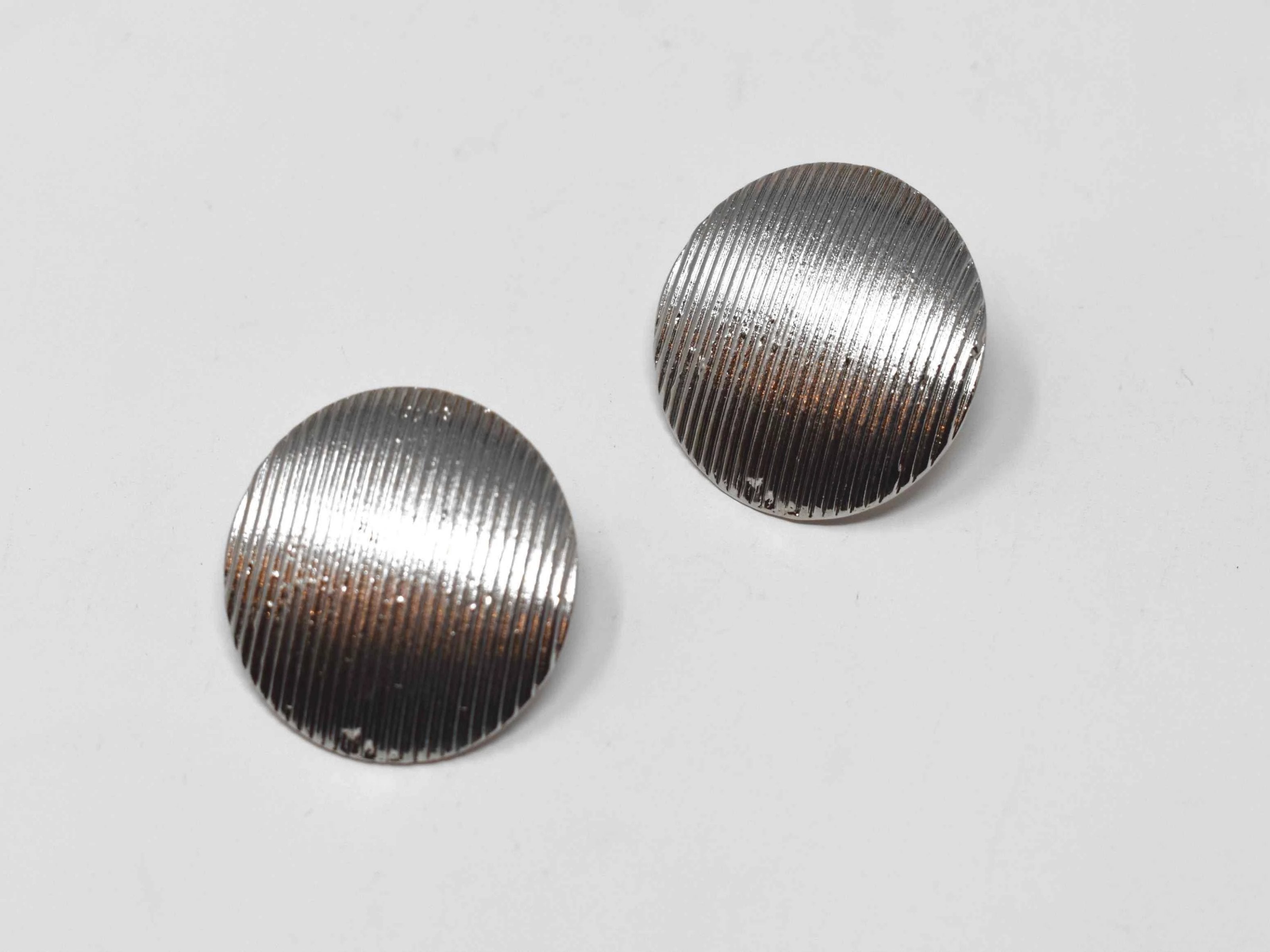 Our Dahli Silver earrings are good for any occasion. They are silver medium sized knob earrings with a pinstripe design and a pushback clasp.