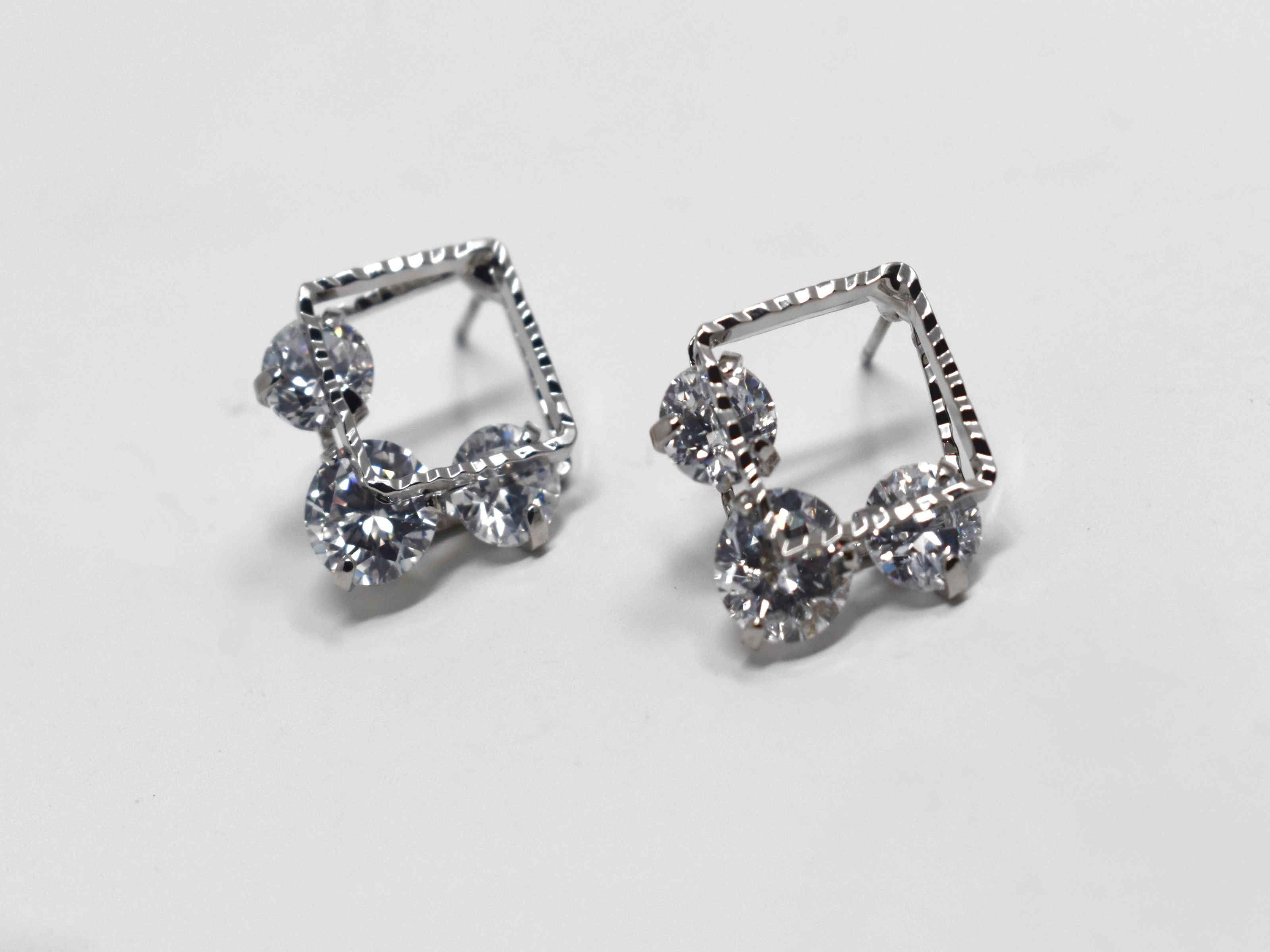 Our beautifully crafted daniella earrings are a must have essential. These silver double square earrings are adorned with stones running between both squares. It is 3/4 of an inch in length with a push back clasp.