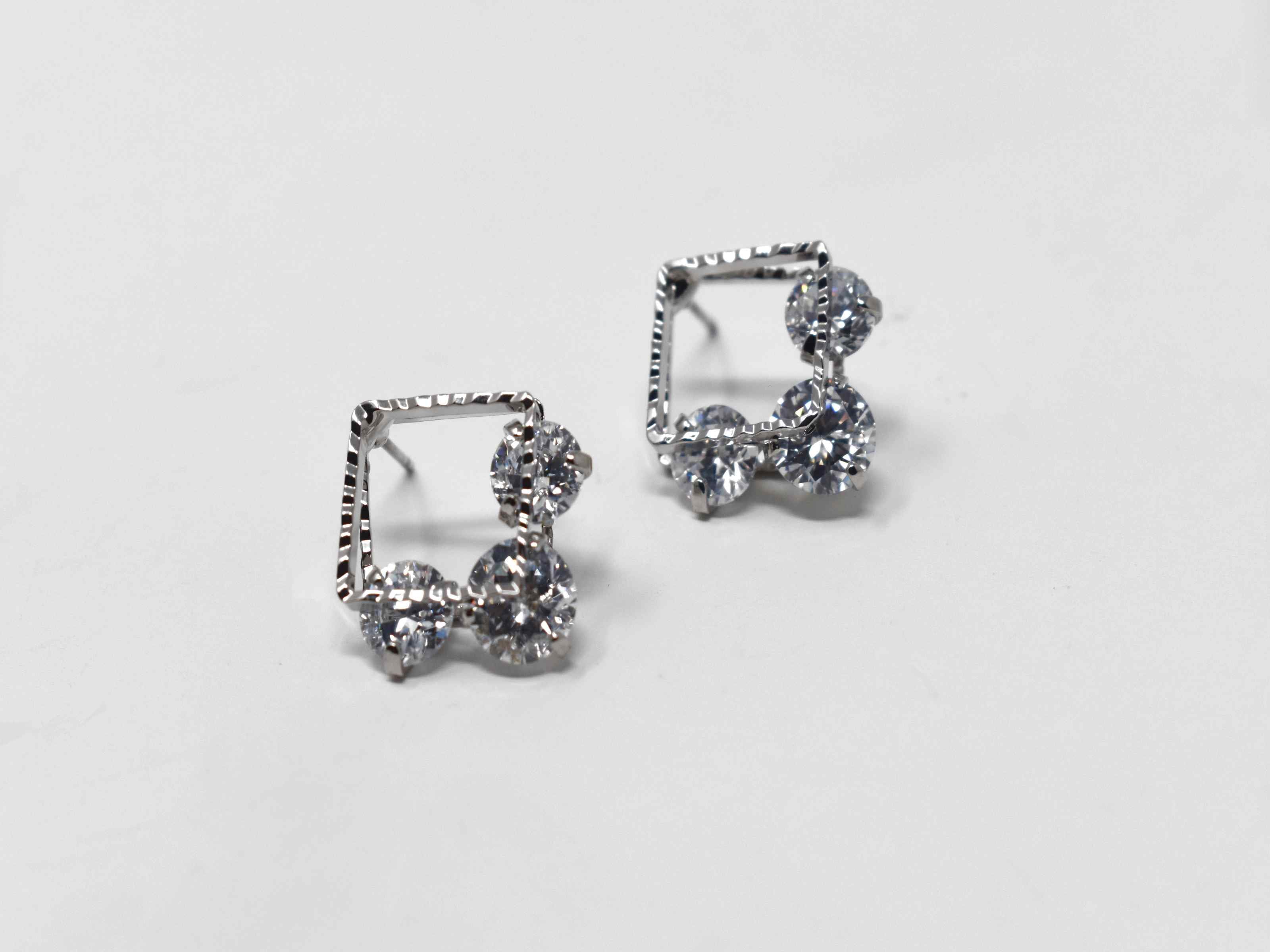 Our beautifully crafted daniella earrings are a must have essential. These silver double square earrings are adorned with stones running between both squares. It is 3/4 of an inch in length with a push back clasp.