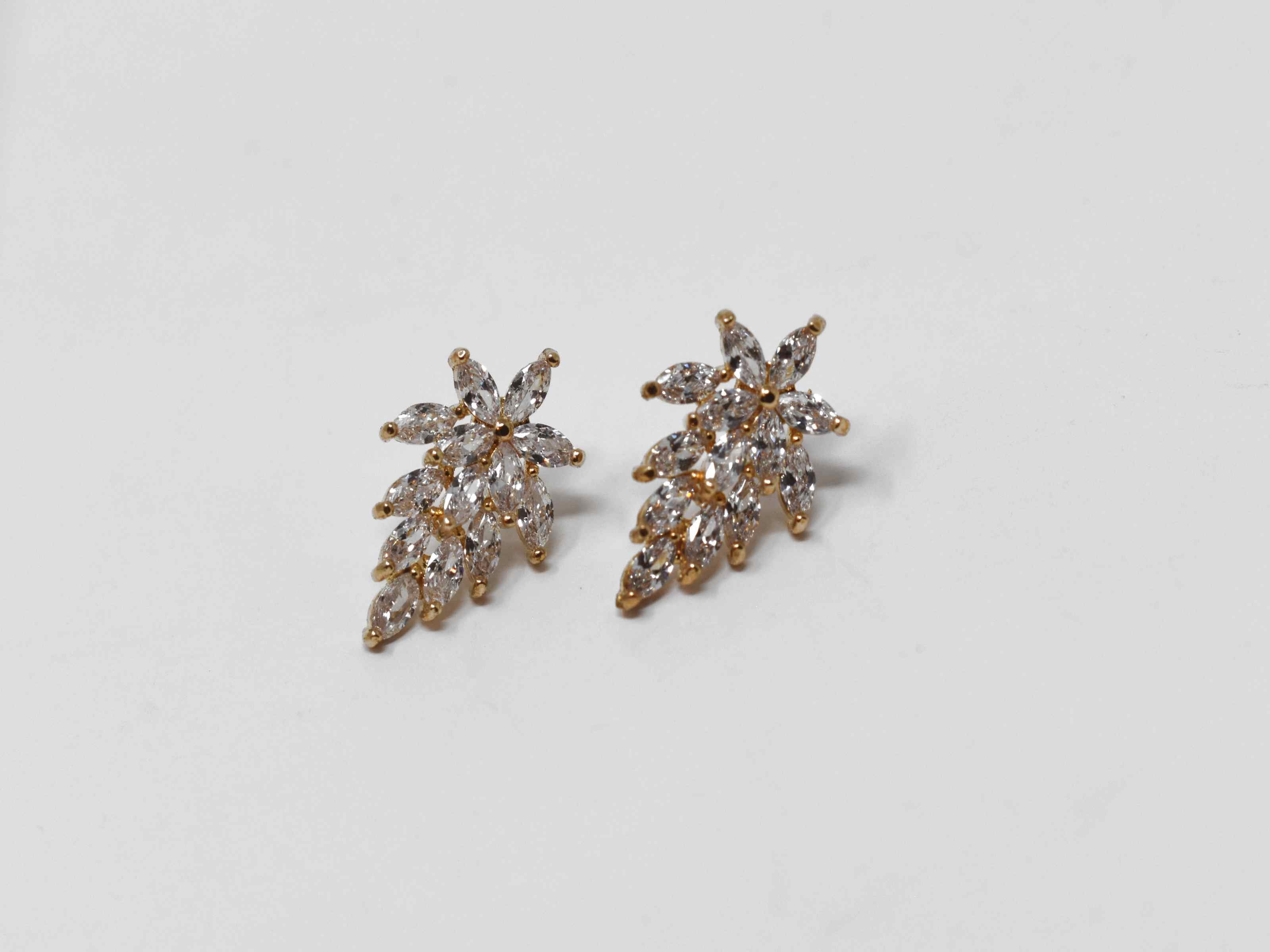 Our Desert rose could be a sweet statement for any occasion.These chandelier knob flower earrings are gold with a burst of clear stones. They are 3/4 of an inch with a push back clasp.