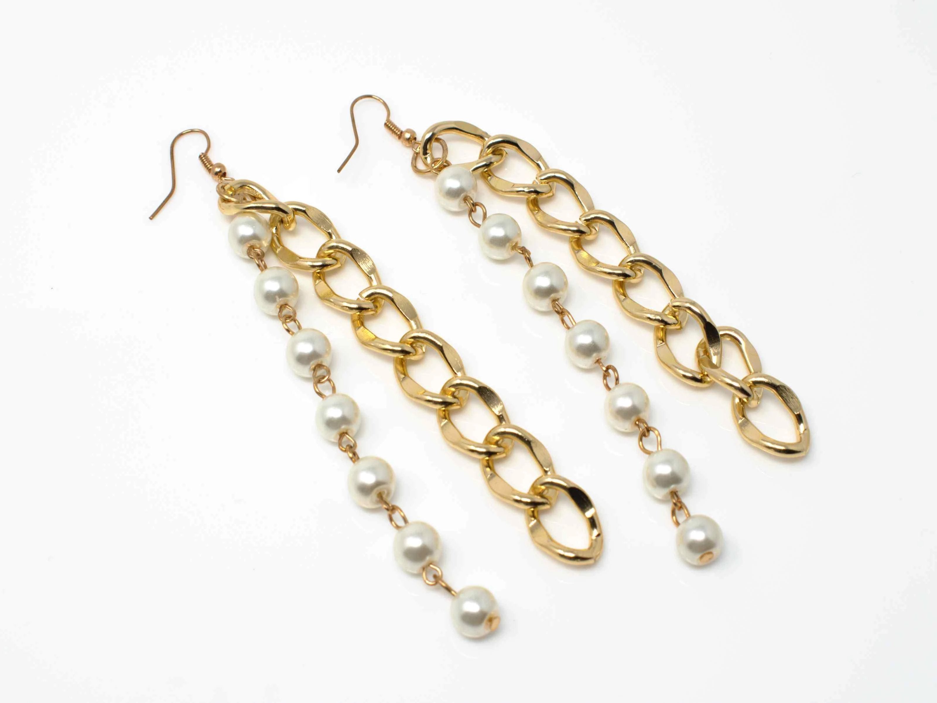 An elegant gold drop dangle earring with pearl accents and a fish hook clasp.