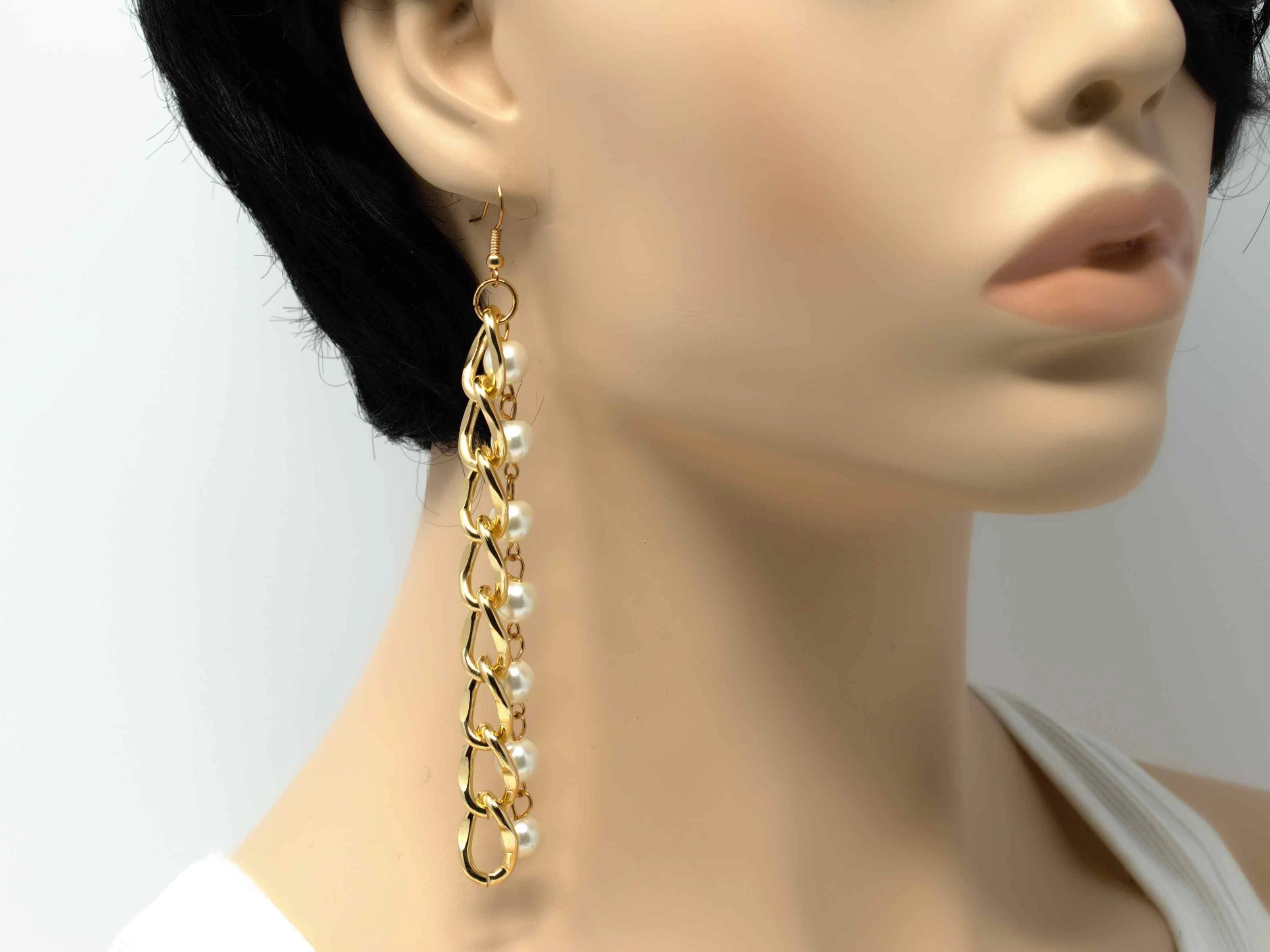 An elegant gold drop dangle earring with pearl accents and a fish hook clasp.