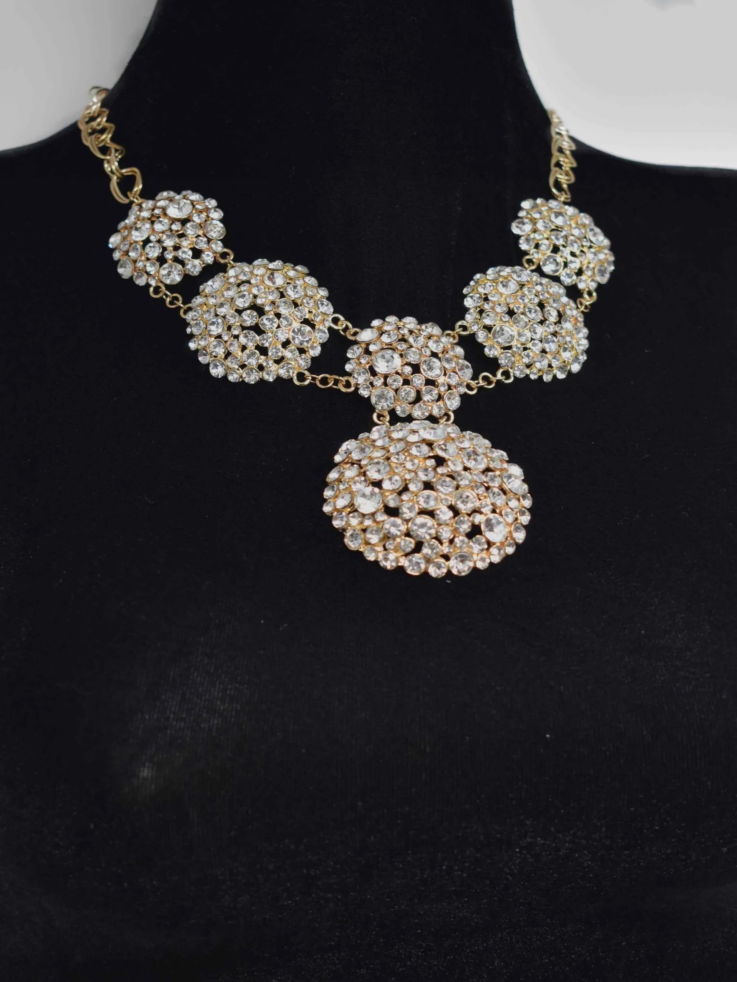 Show them how its done once you show up in our Ella statement necklace. This gold statement piece is covered in clusters of clear stones and closes off with a lobster clasp. It measures 10 1/2 inches in length.