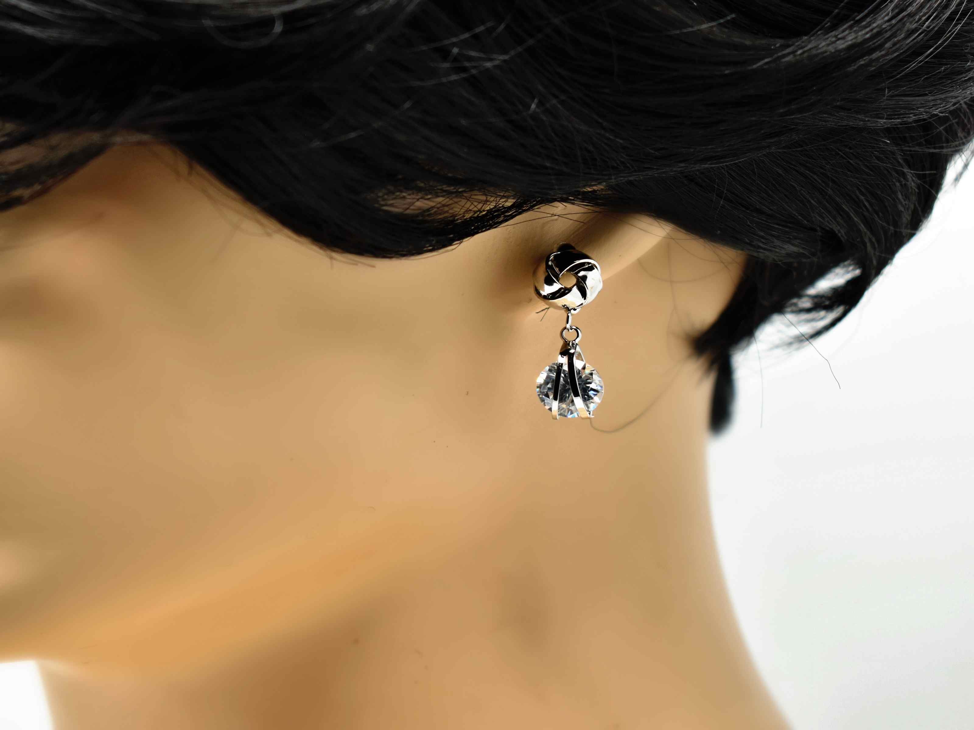Our Erica earrings are so delicate and chic! These little silver beauties are the perfect knob chandelier earrings with a knot design and a drop dangle stone. It has a push back clasp and is 1 inch in length.
