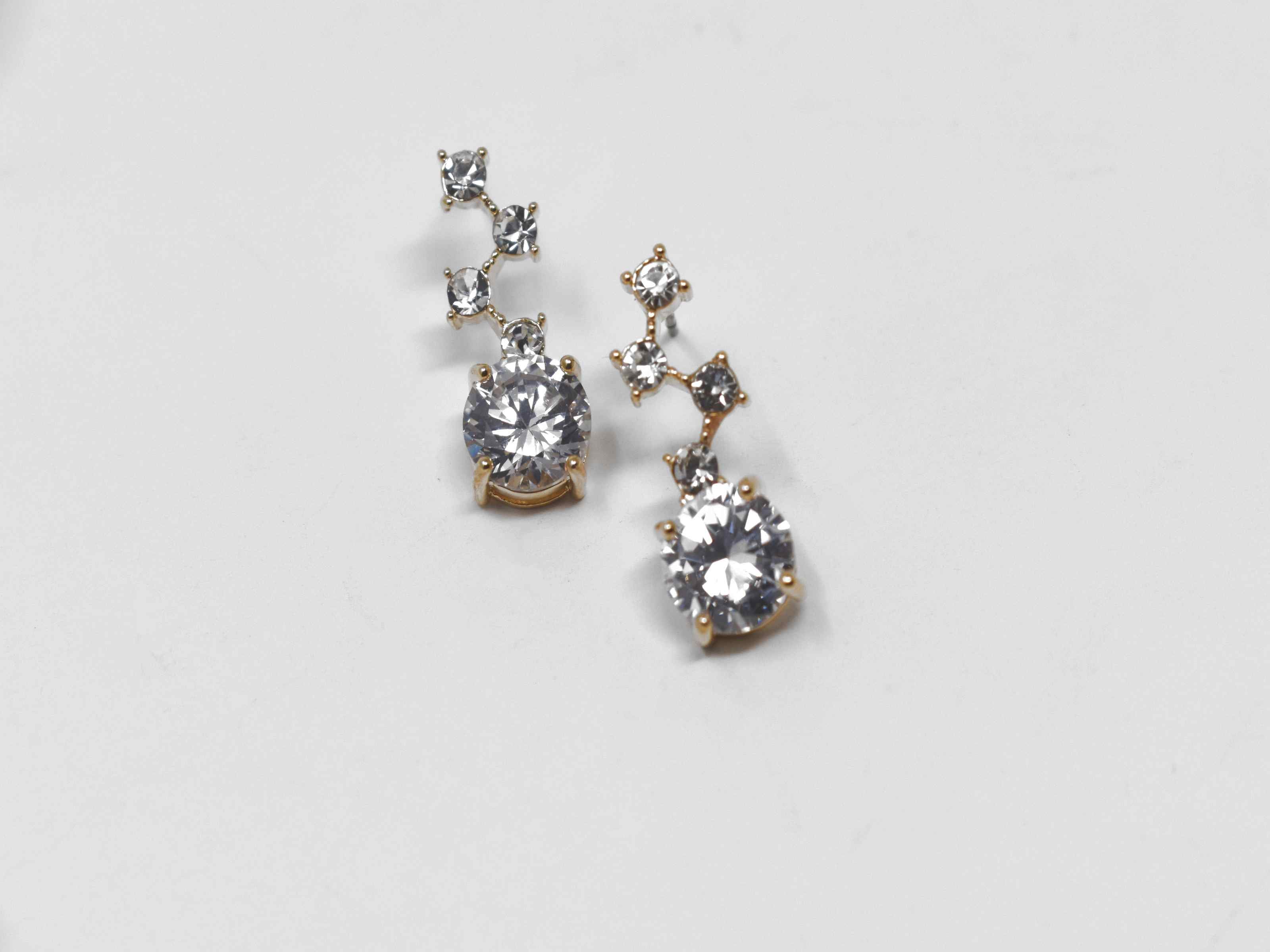 Our Flannel earrings are a must have! These gold earrings are a dangly knob connected with stones. It is 3/4 of an inch in length with a push back clasp.