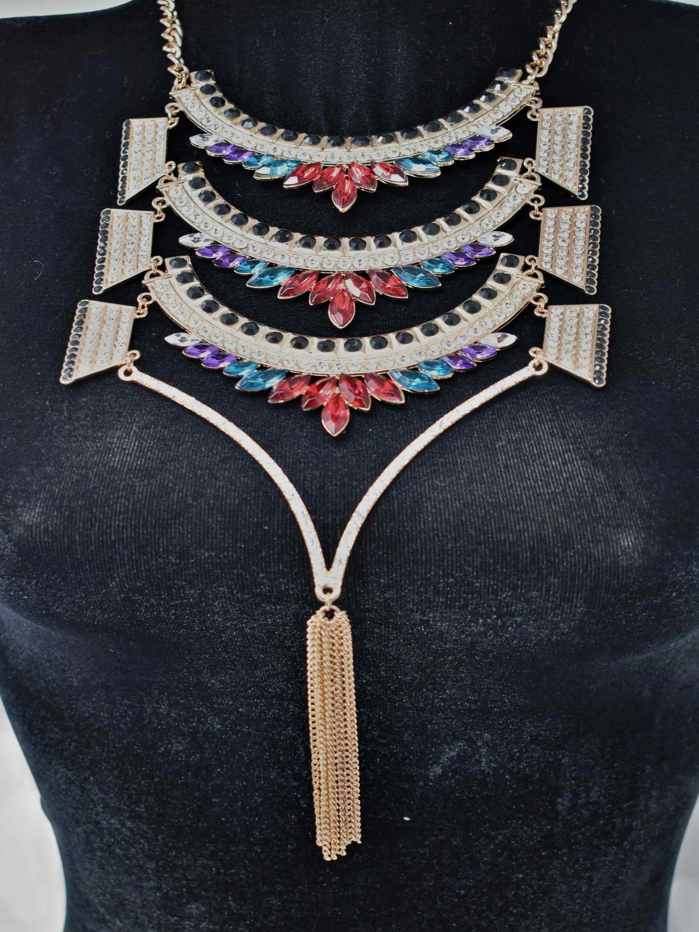 Dare to dazzle with our Greta statement necklace. This Gold necklace is a stunner with its multicolor stones and fringe tassels. It measures around 17" in length and has a lobster clasp.