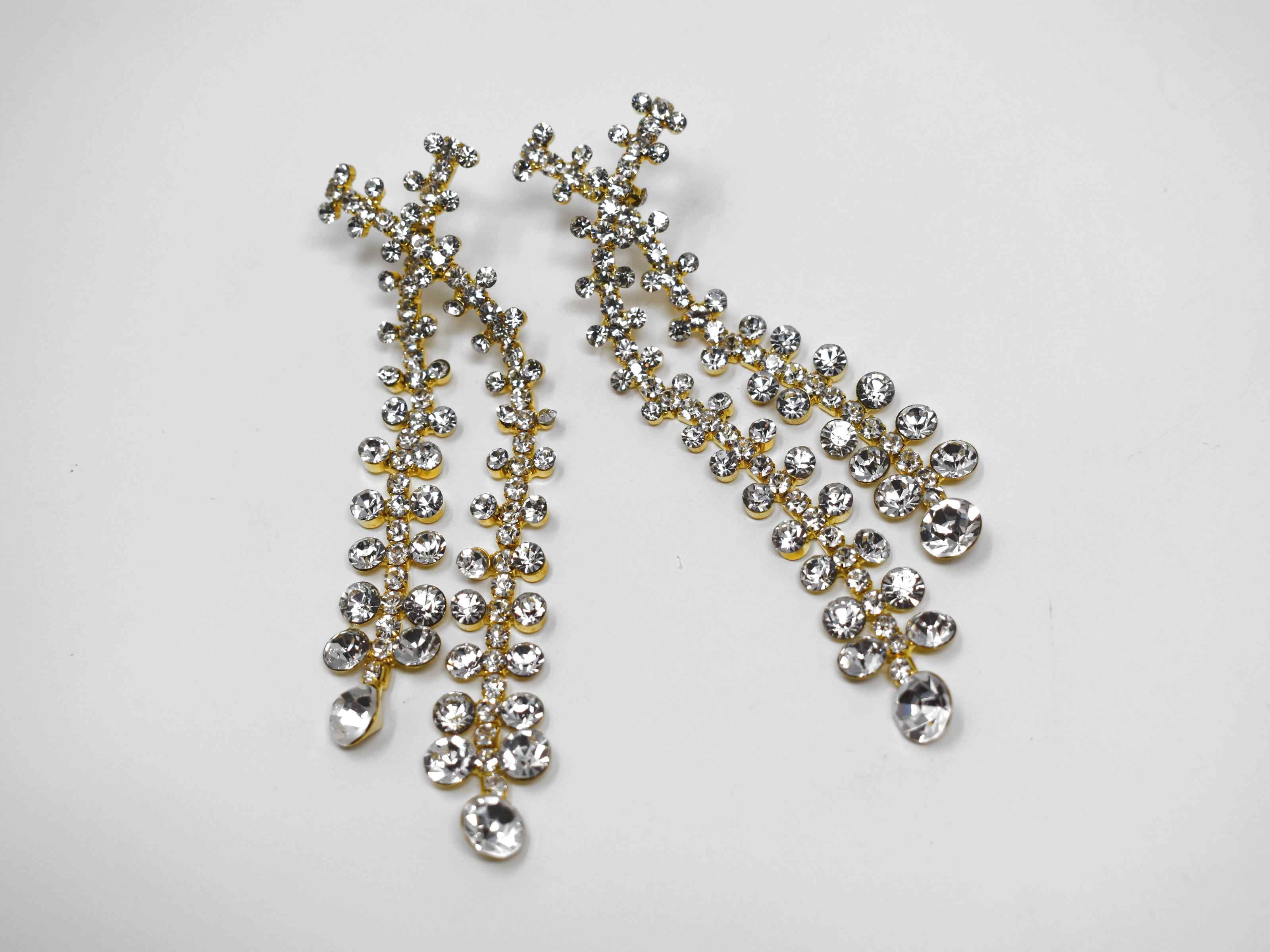 Detailed and distinctive our gypsop formal drop dangle statement earrings are gold with a cluster of clear stones.These earrings are 3 1/2 inches in length with a push back clasp.