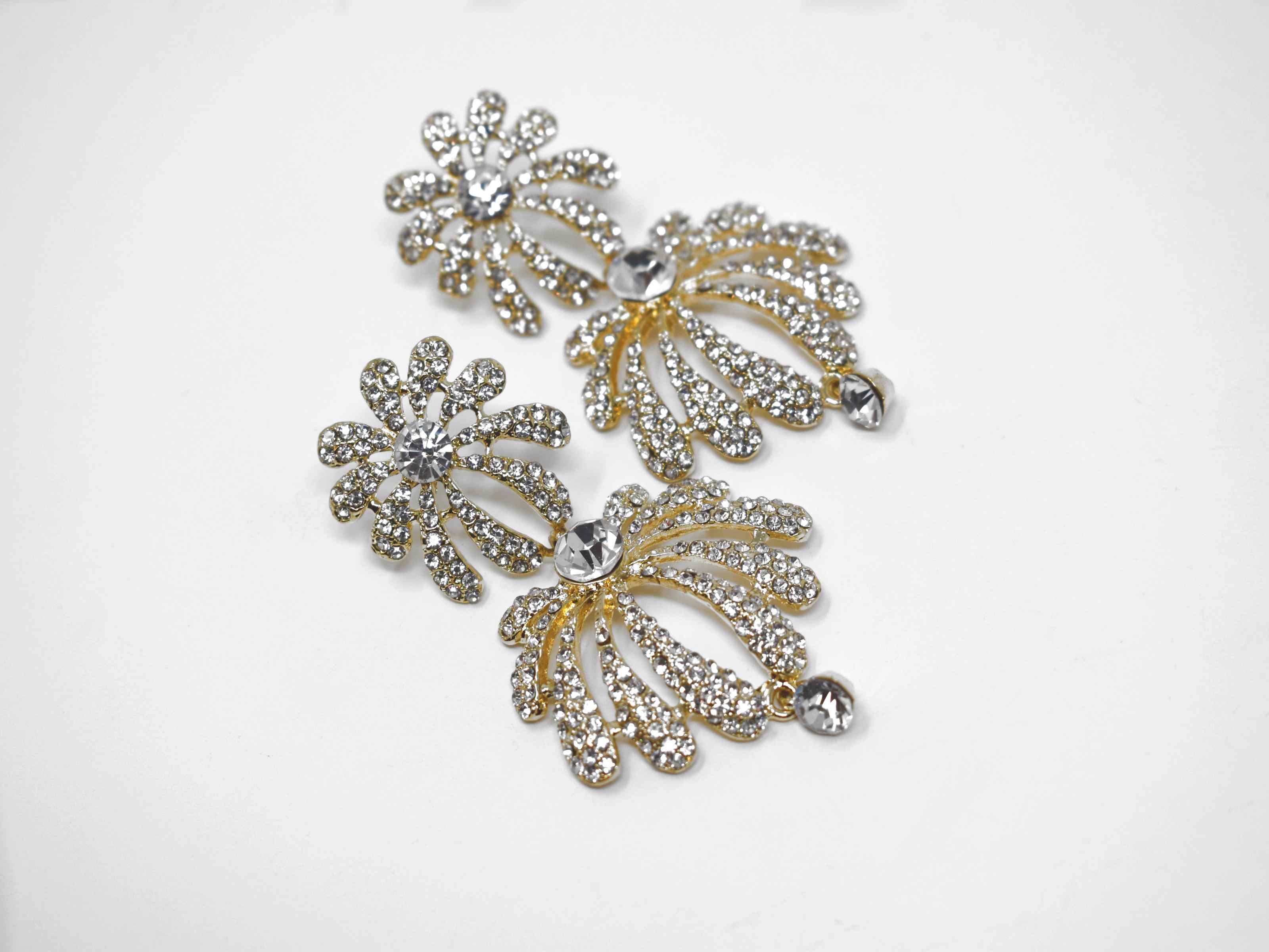 A radiant burst of sparkle is how you would describe our helenium gold earrings. These are a two tier floral burst formal drop earring with clear stones. They are 2 1/2 inches in length with a pushback clasp.