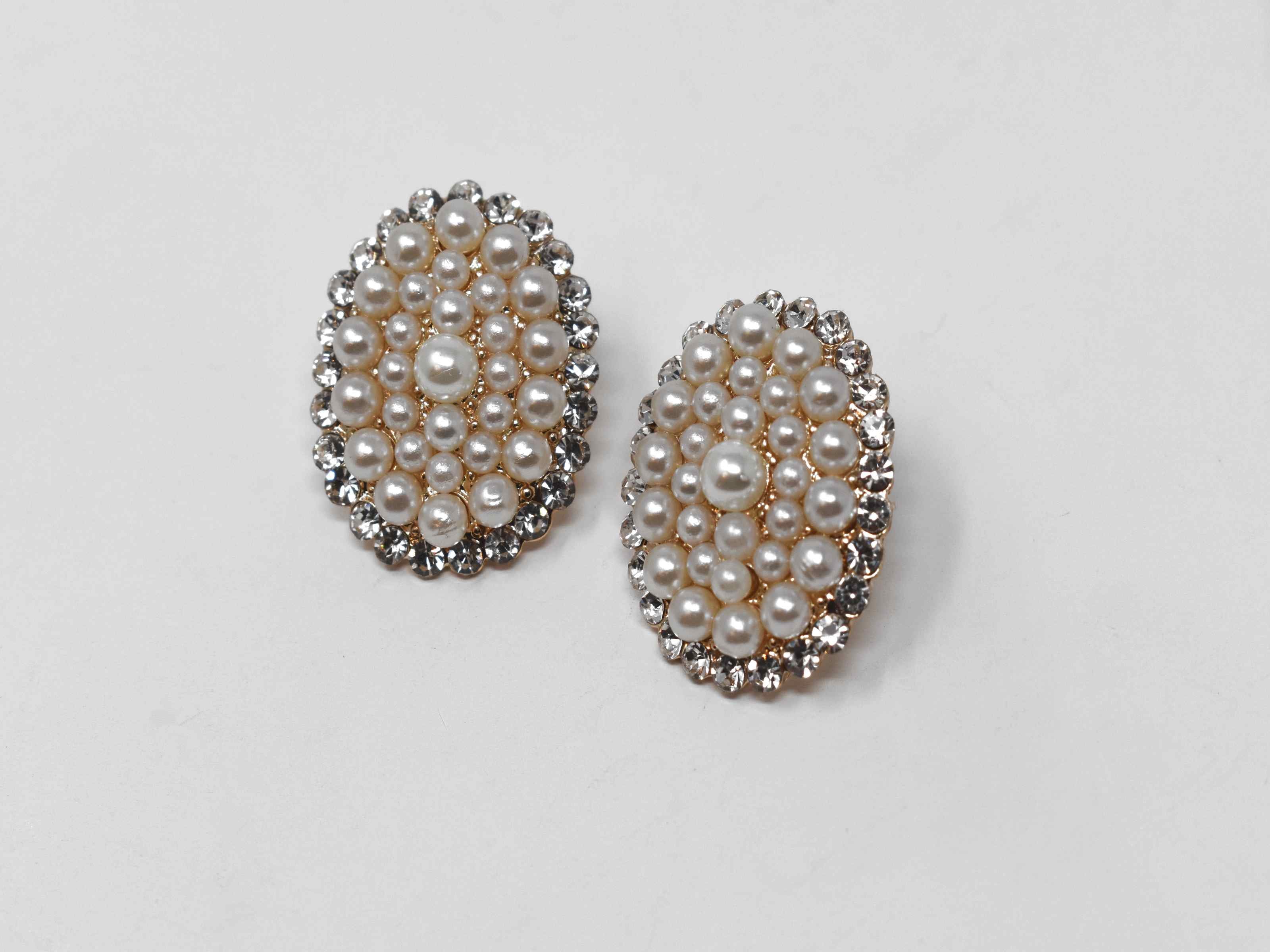 Our adorable Hosta knob earrings is the perfect addition to your wardrobe. Its oval shape is covered in pearl clusters and and has a gold tone with a push back clasp.