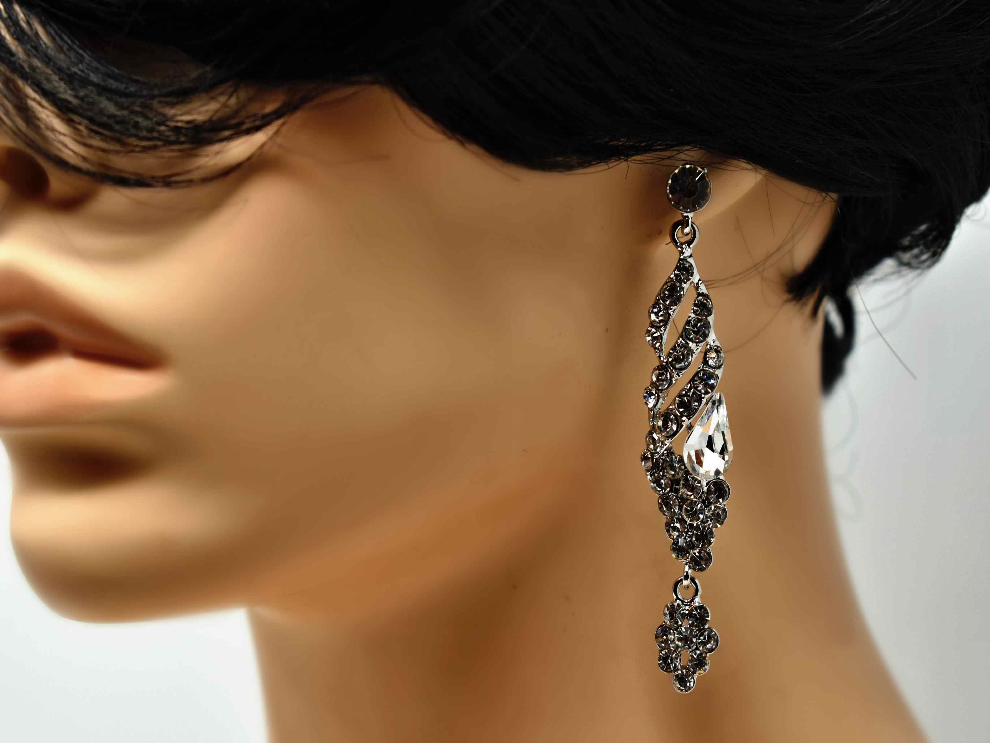 These formal silver earrings are a classic addition to your outfits. They are 3 inches in length and encrusted with clear stones. 