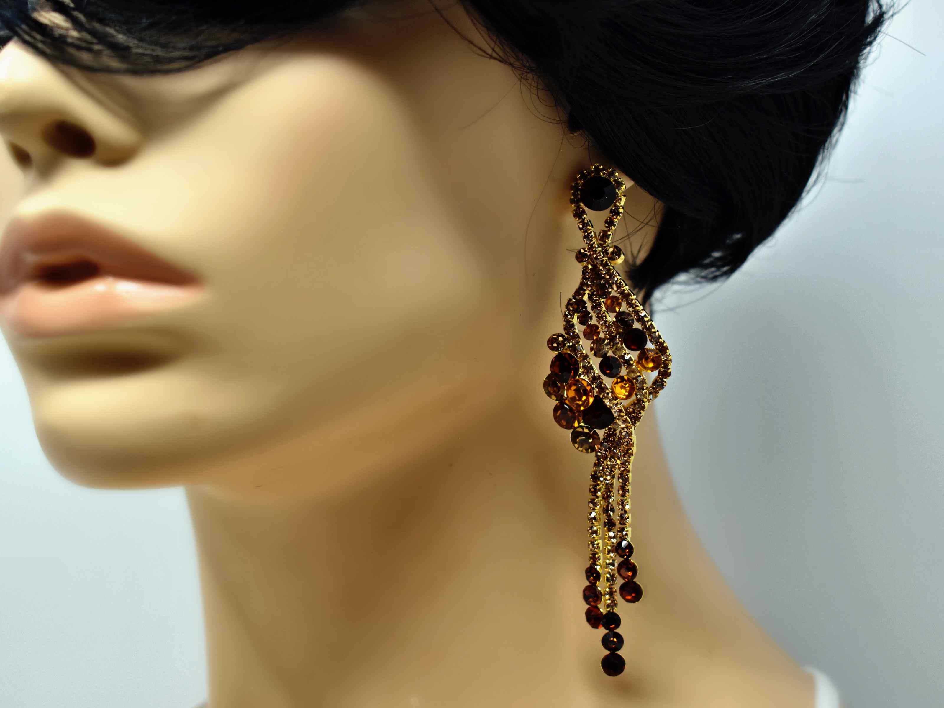 Our Stunning Ixia dangle gold statement earrings are a sure show stopper. These earrings with their tan and brown stones are 4 inches in length with a push pack clasp.