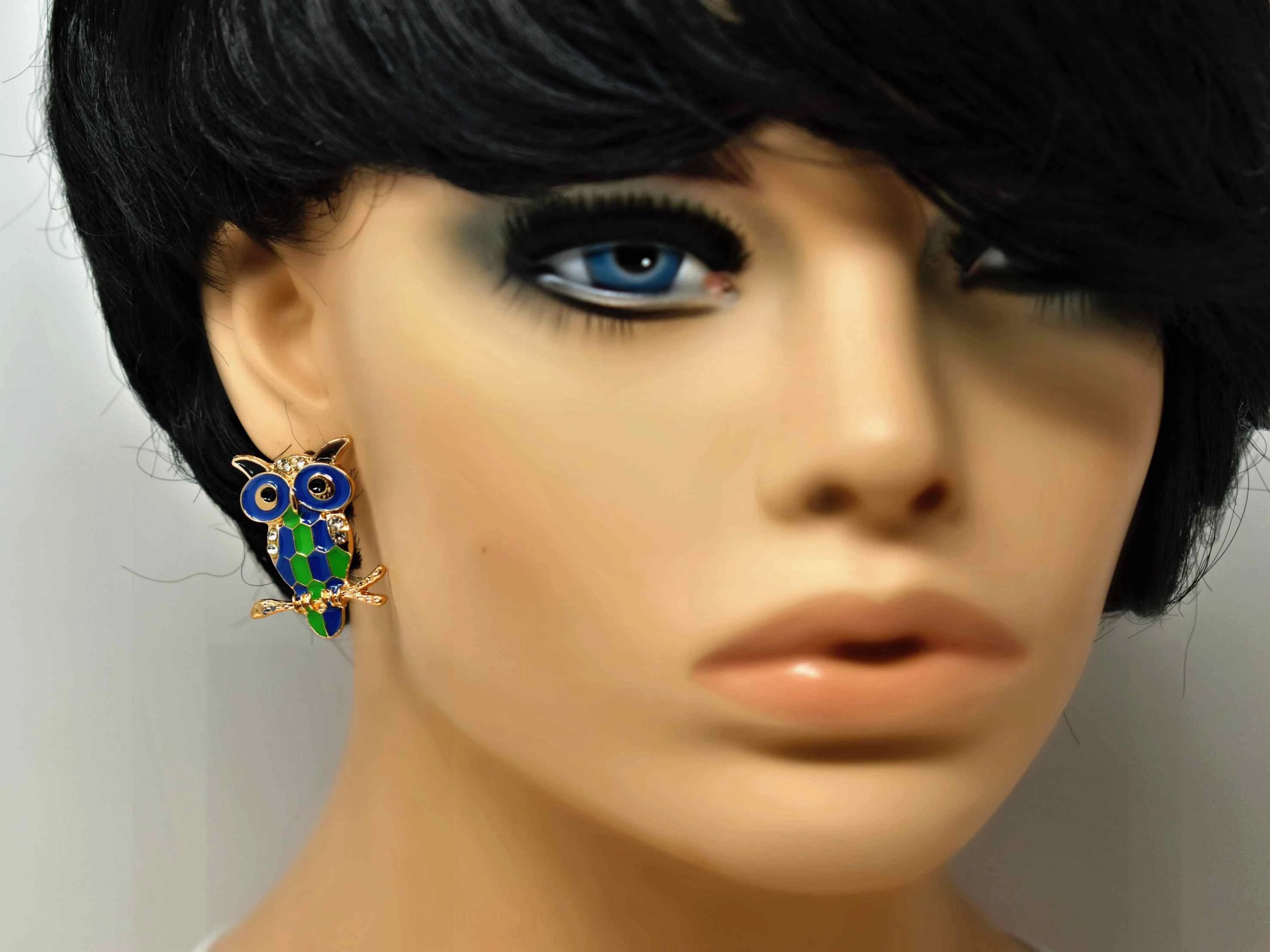 Jazzy's whimsical green and blue owl shaped earrings has a push back clasp with stone features and measures 1 1/2" in length.  Gold Tone 1 1/2 in length