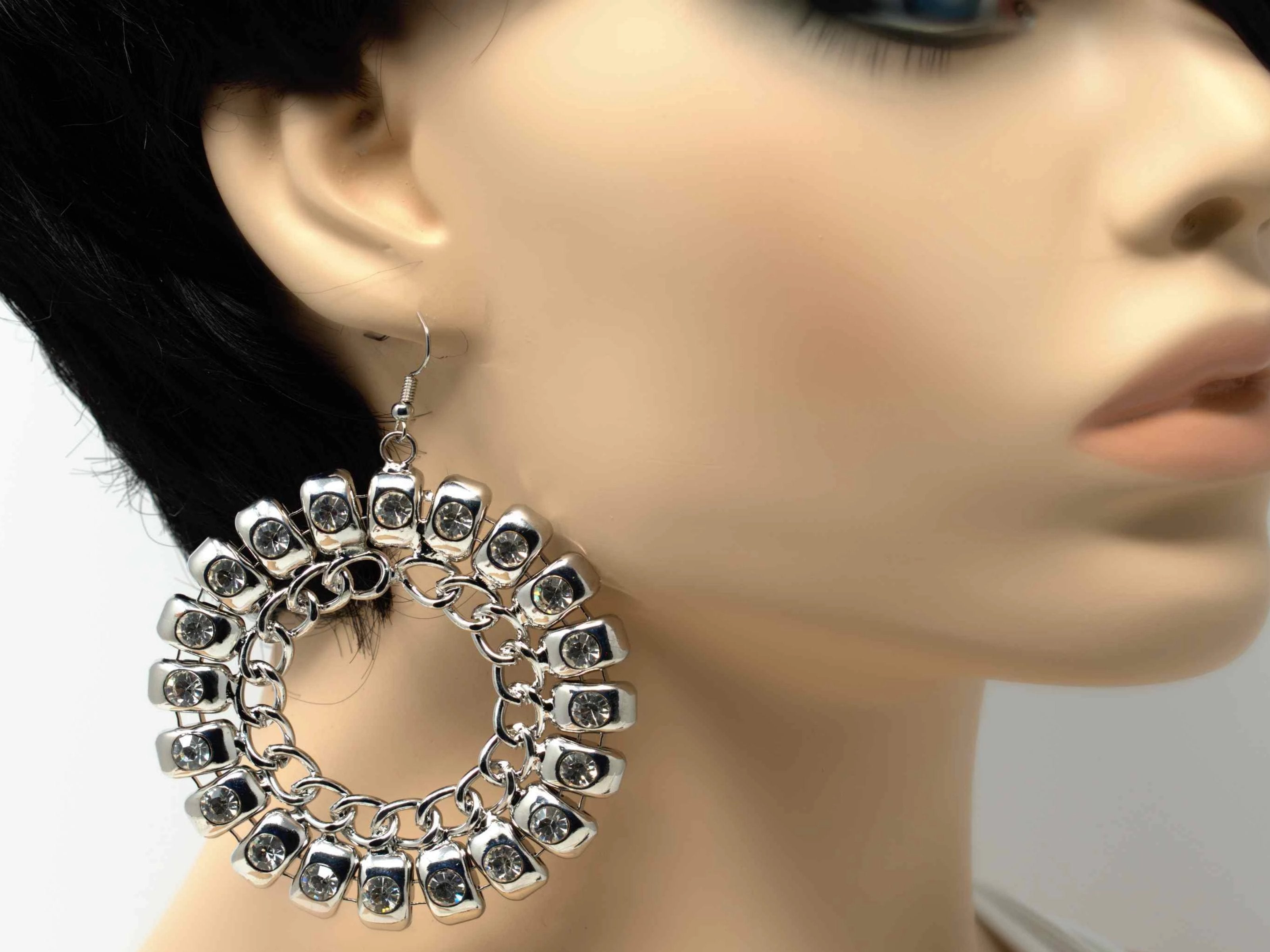 An exquisite silver dangle drop fashion earring with stones and chain accent and a fish hook clasp.