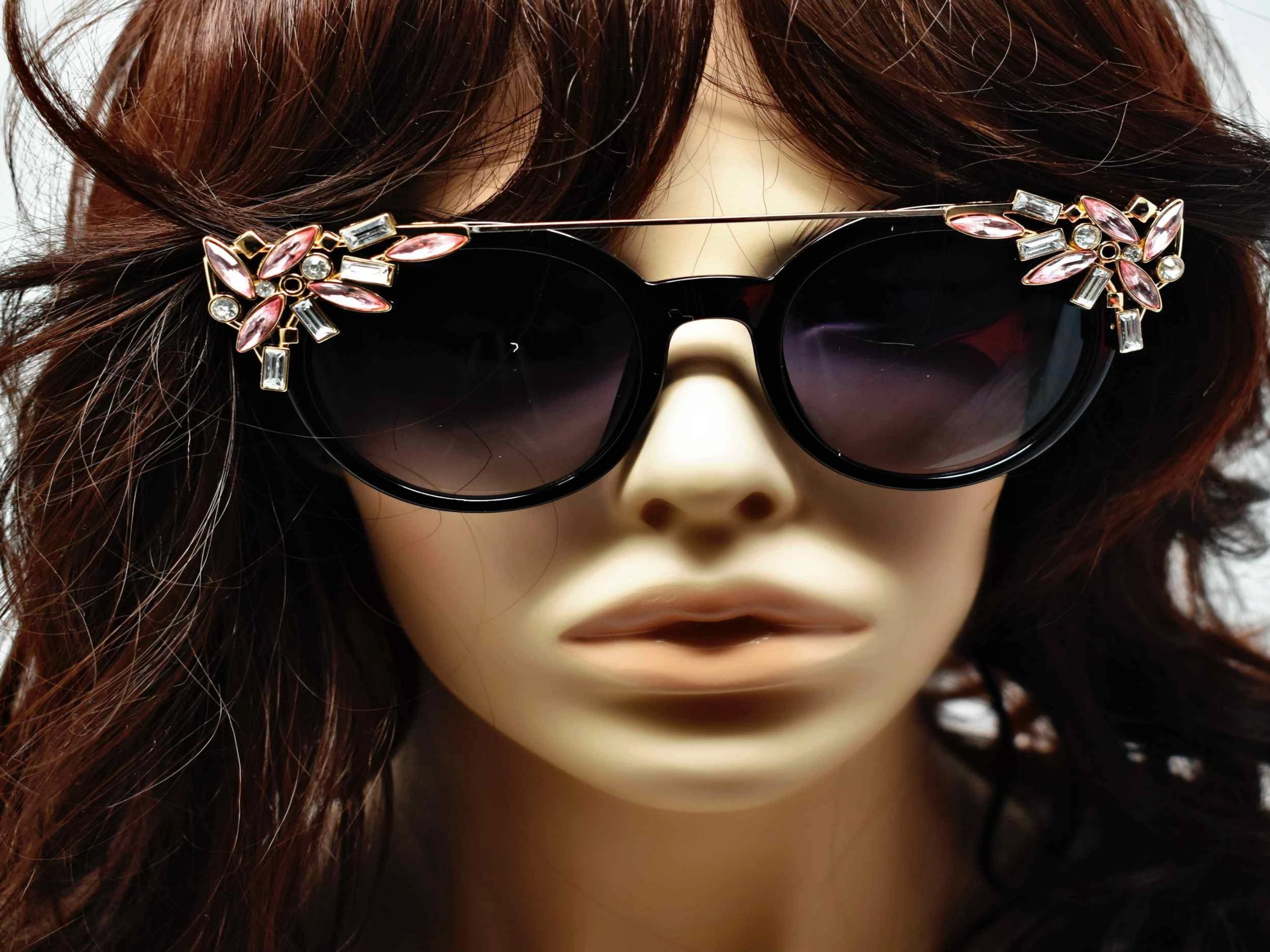 Trend setter and attention getter is what they will call you in these Pansy black sunglasses with a sleek gold trim adorned in pink and clear gems, in a pantos style frame.