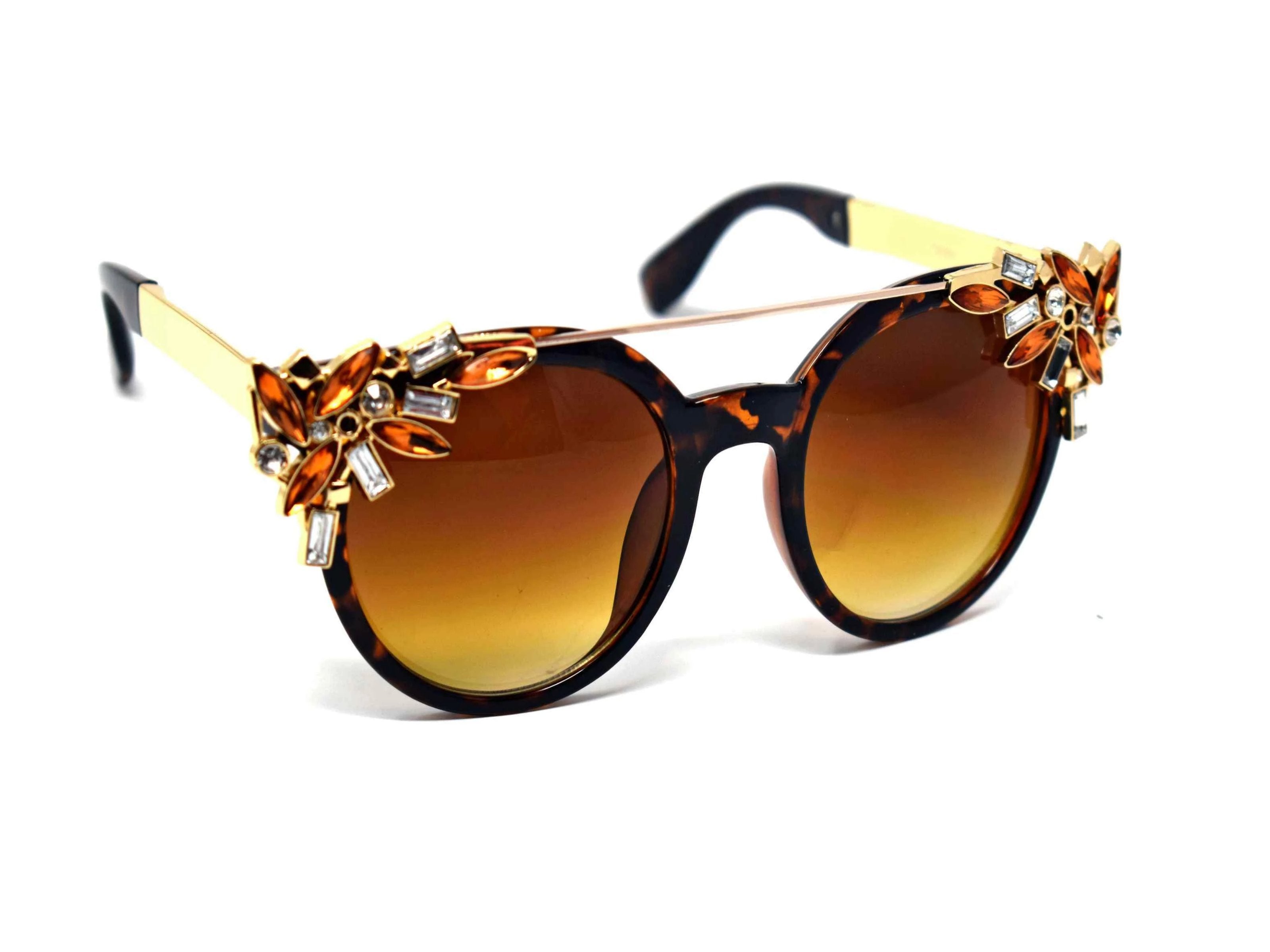 Trend setter and attention getter is what they will call you in these Pansy Leopard sunglasses with a sleek gold trim adorned in clear and brown gems, in a pantos style frame.