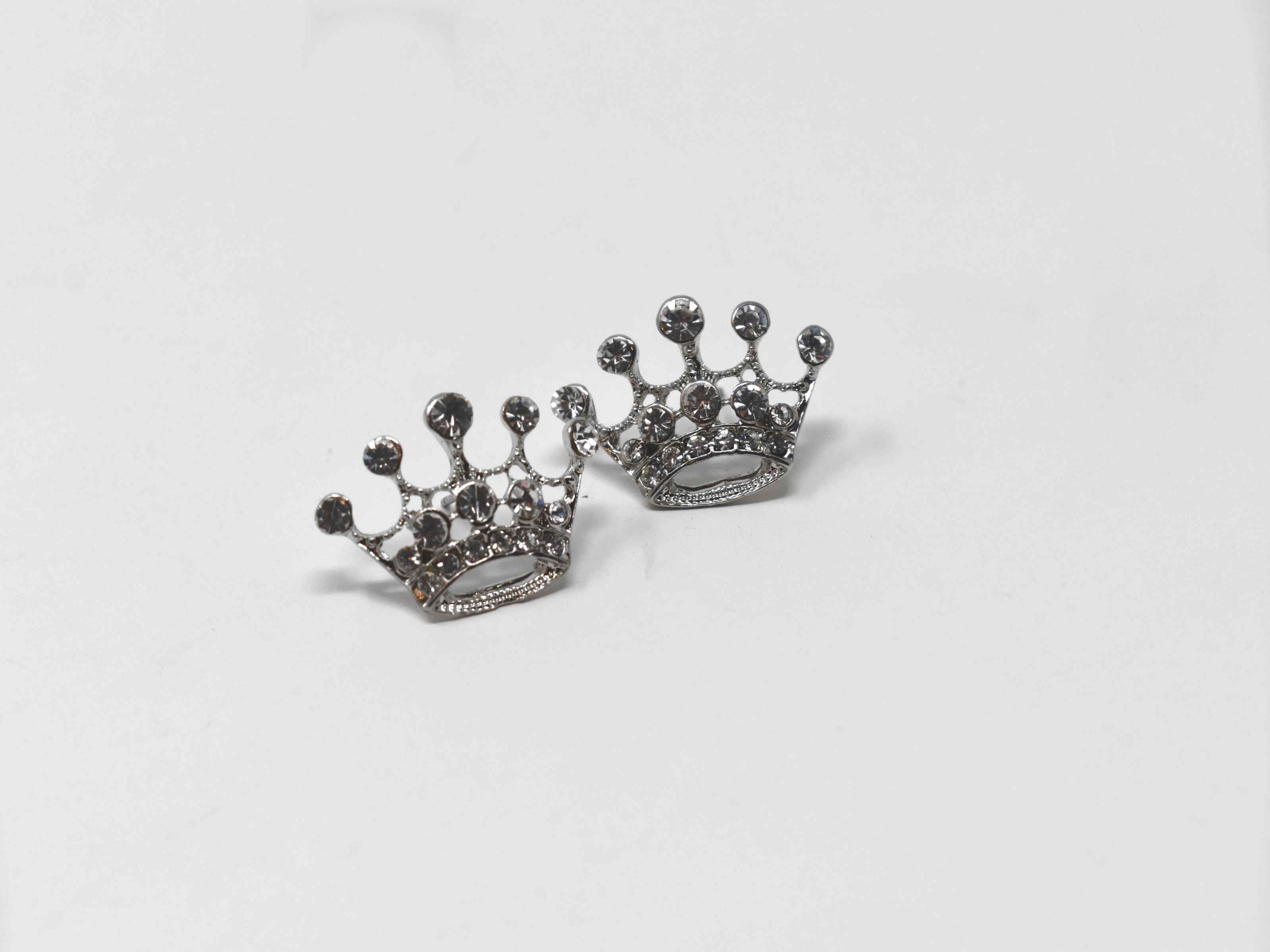 Let our queens cup be your new essential go to staple. These silver knob crown shaped earrings are encrusted with stones, 1/2 an inch in length with a pushback clasp.