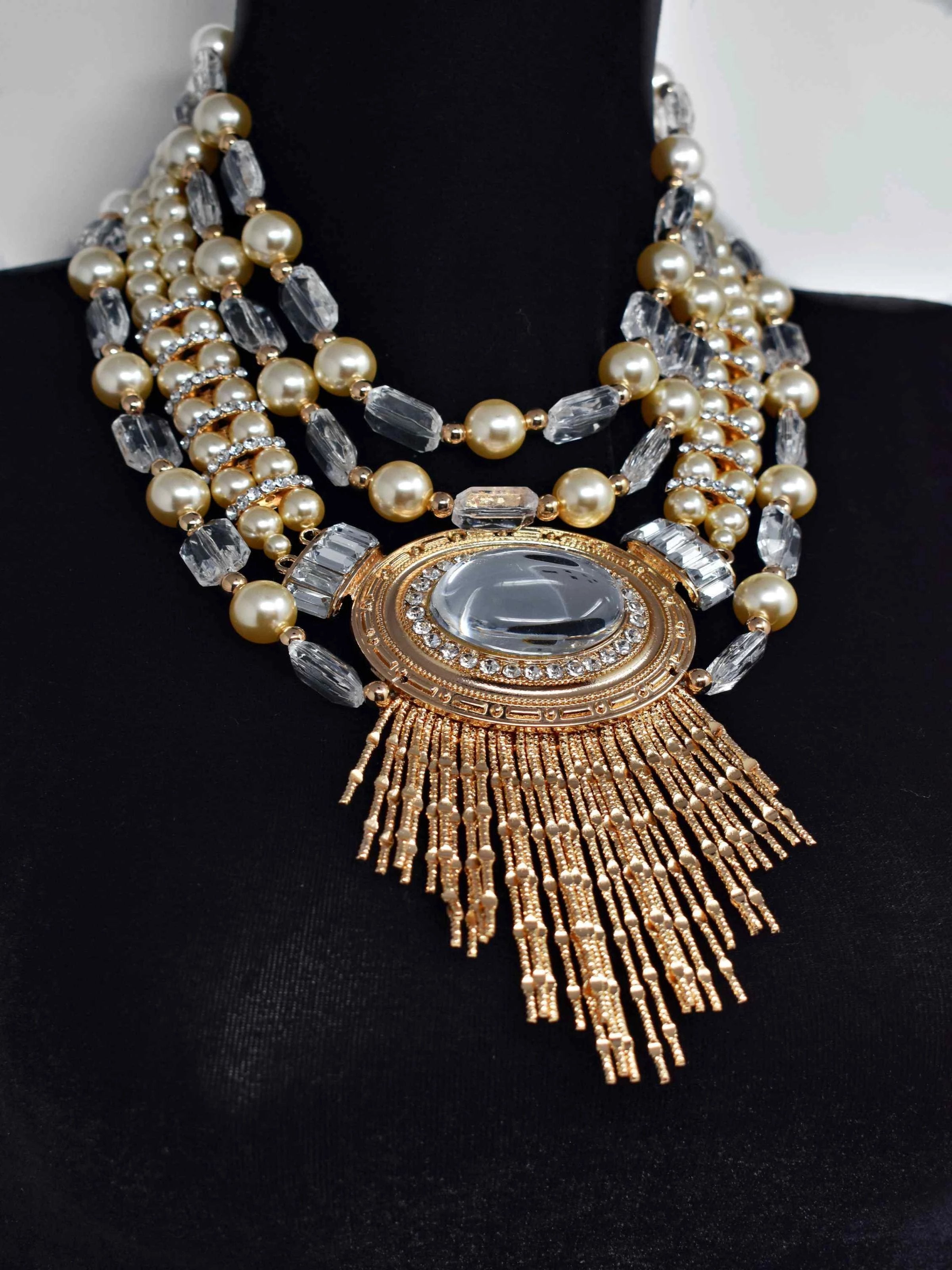 Our Rium gold and pearl necklace makes a standout addition to your collection.  This multi strand statement necklace is 17" in length with a lobster claw clasp.
